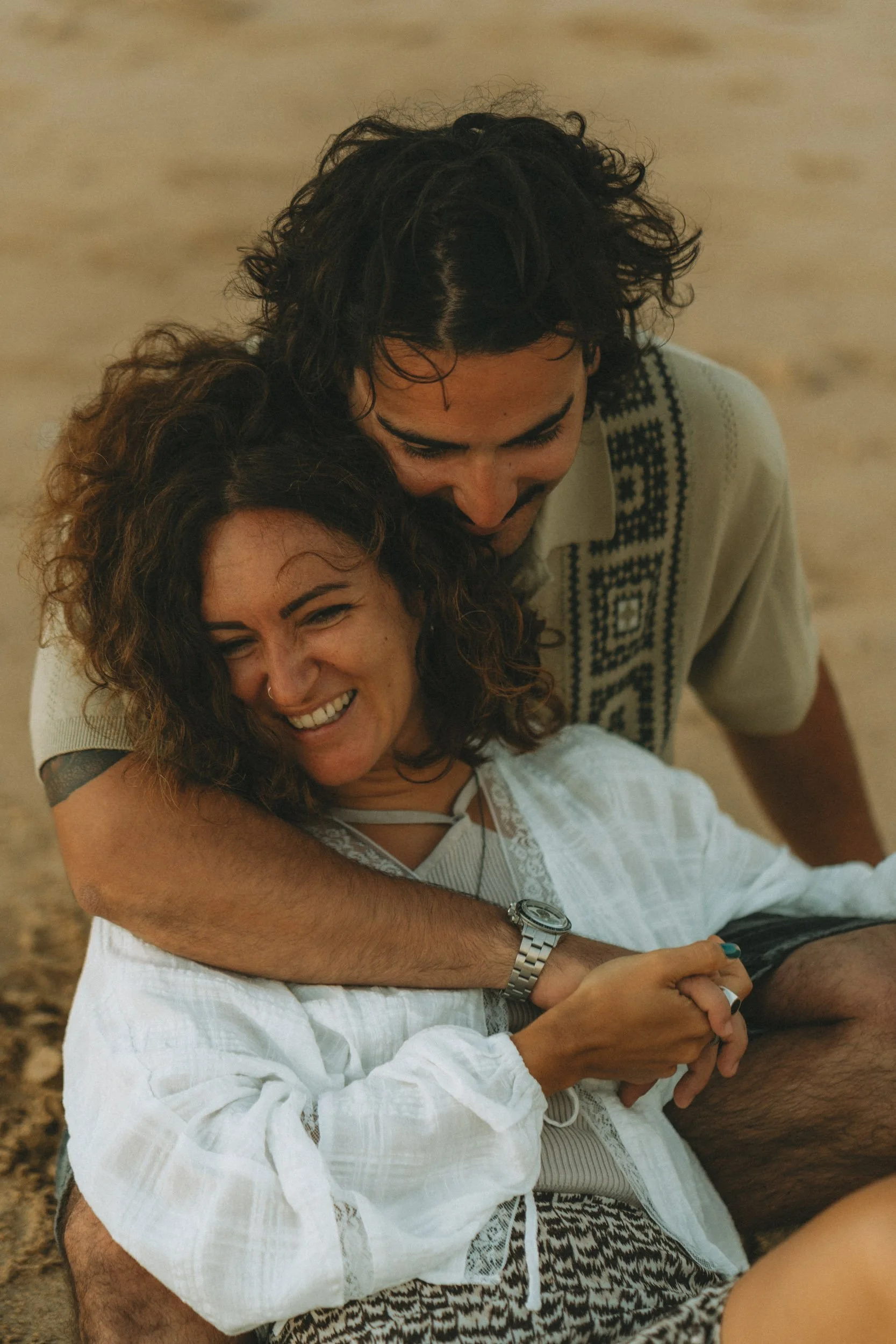 Intimate romantic moment captured at golden hour on Praia dos Três Irmãos, Algarve, couple photography with a warm earthy colour palette.