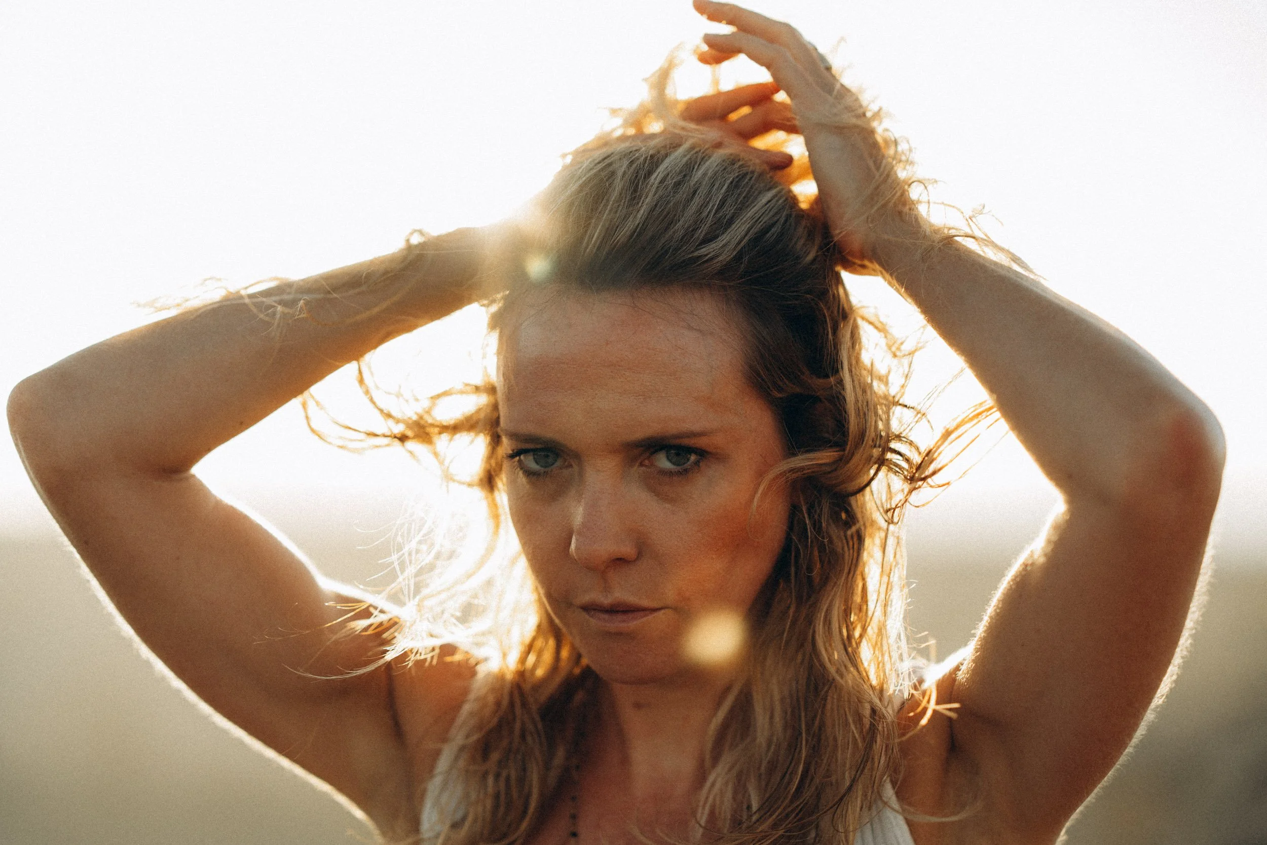 Backlit creative portrait photography — sunset light shaping mood and texture on Sagres beach