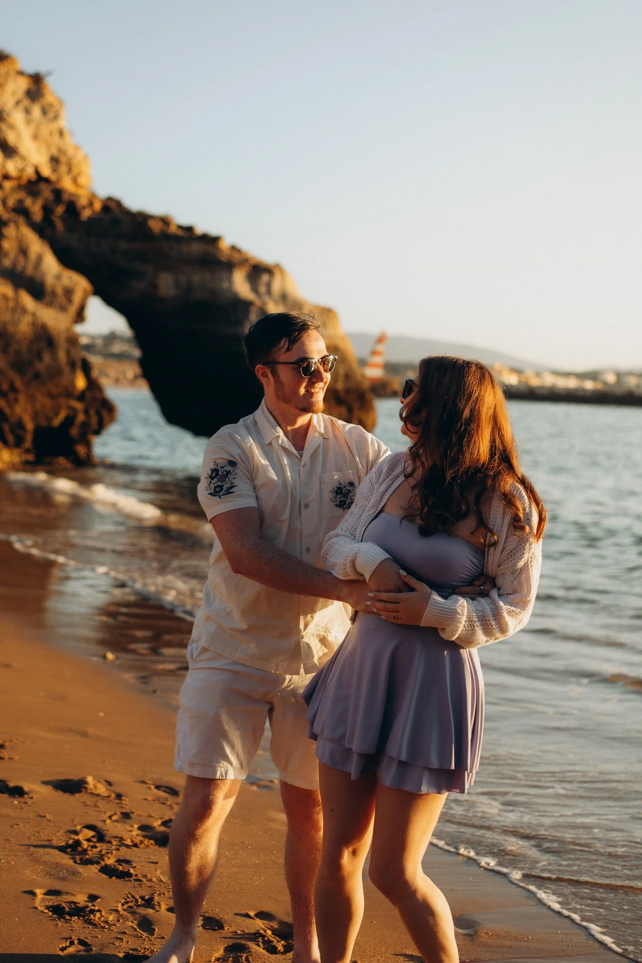 Couple hugging on the beach at Praia dos Estudiantes during golden hour photoshoot in the Algarve