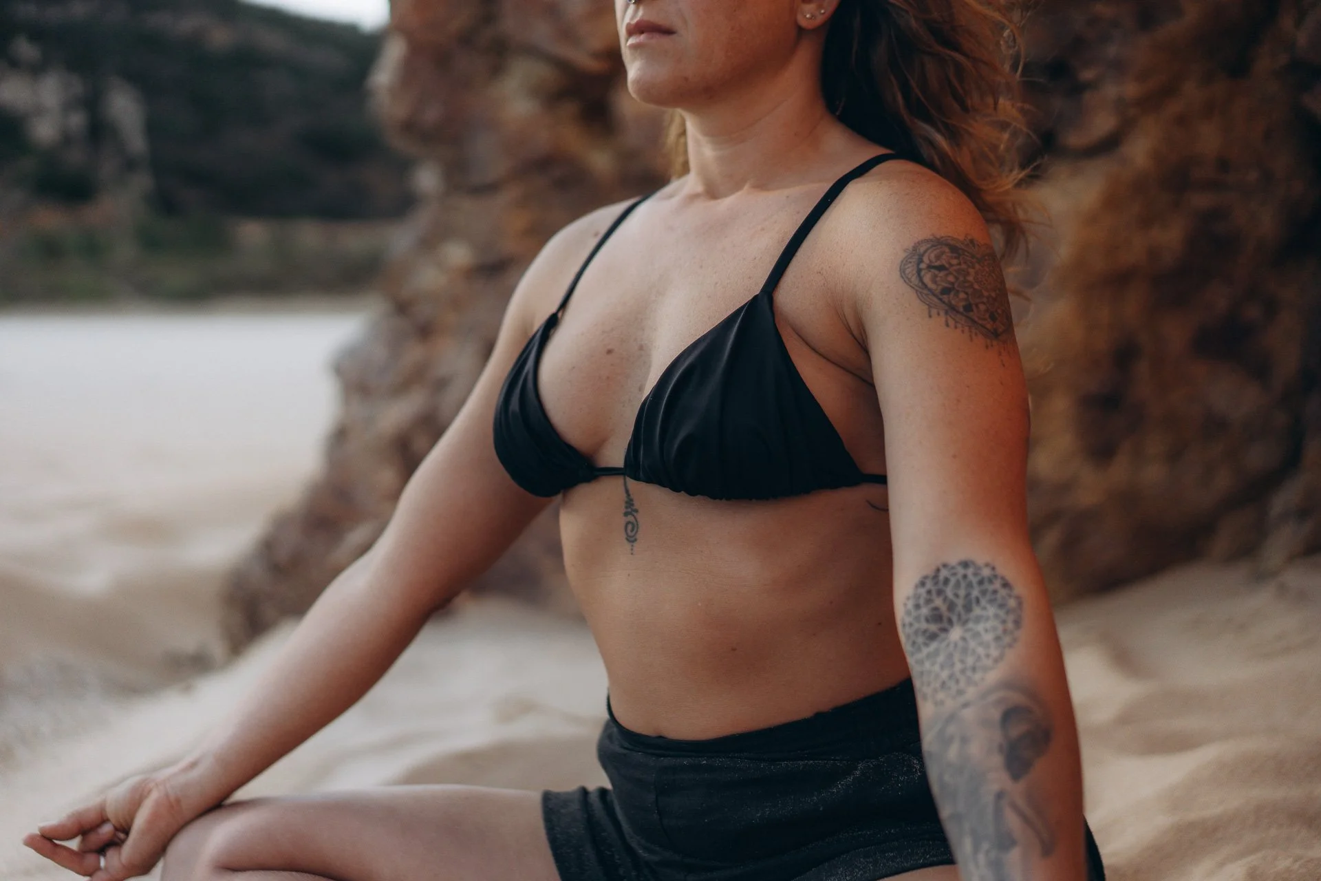 Minimal yoga composition on an empty Algarve beach, emphasizing space, calm, and simplicity.