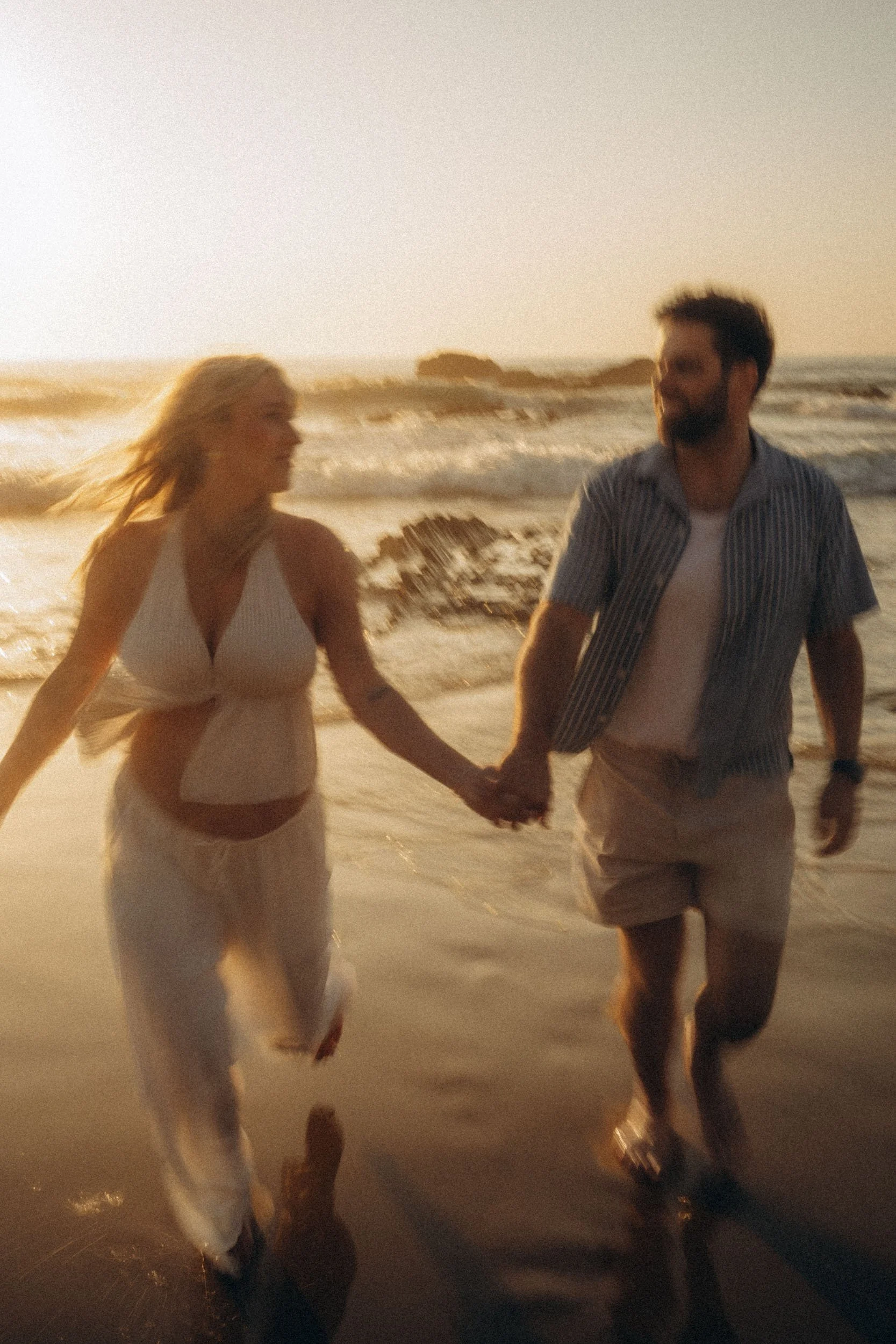 Cinematic motion-style couple photoshoot running along shoreline in Sagres Algarve, showcasing dynamic storytelling and golden hour energy.