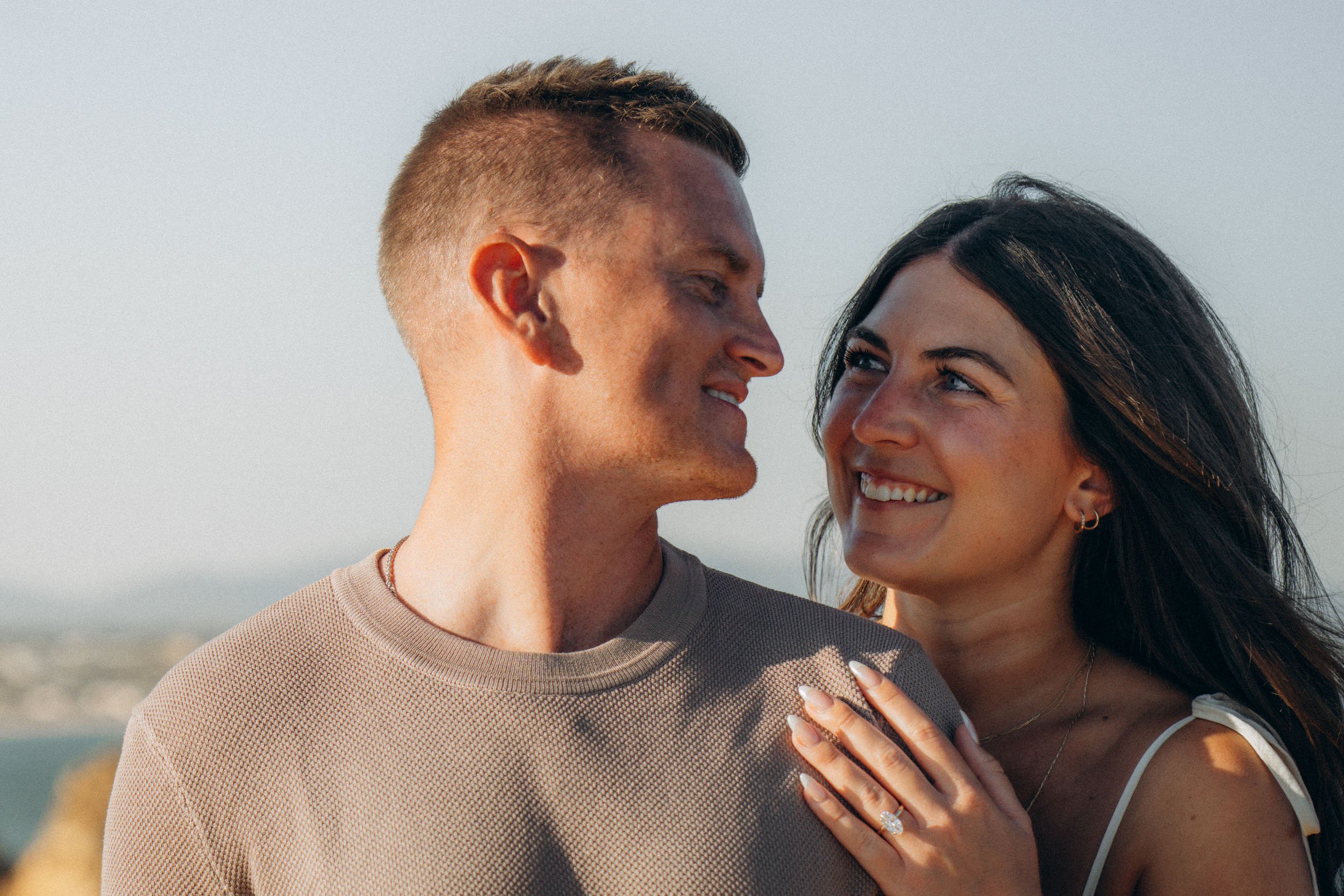 Champagne toast after the proposal. Natural golden light hits the ring and glass details — celebrating the moment without over-staging.