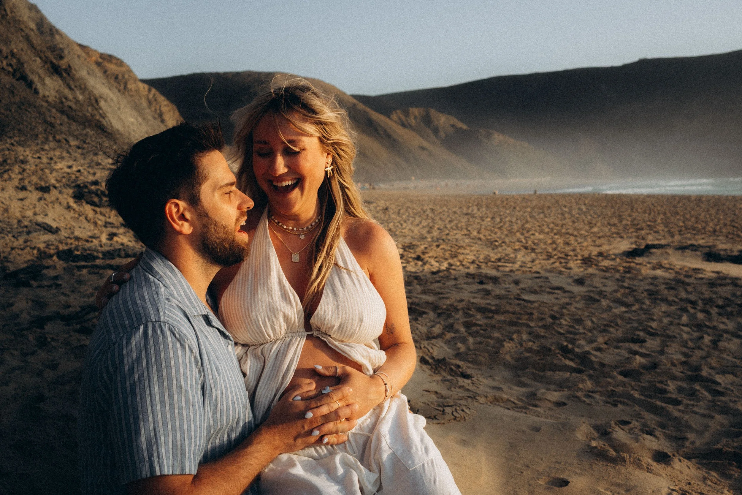 Maternity couple photoshoot on the Algarve coastline, celebrating pregnancy and connection through relaxed, natural beach photography.