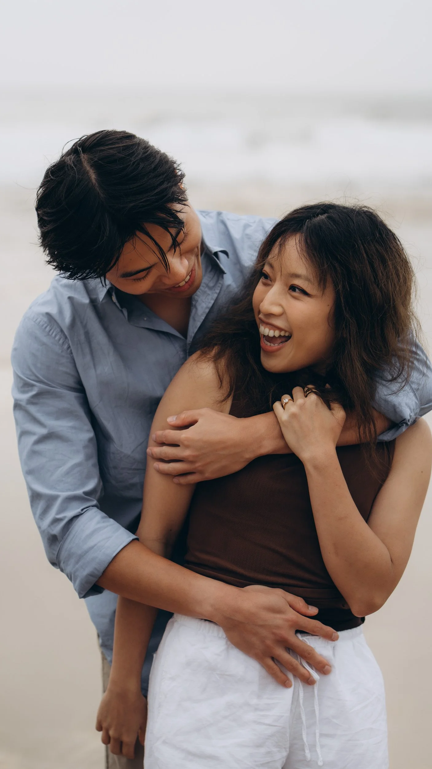 Intimate couple session on the Algarve coast featuring soft interaction and candid emotion, ideal inspiration for engagement, proposal, or lifestyle beach photoshoots.