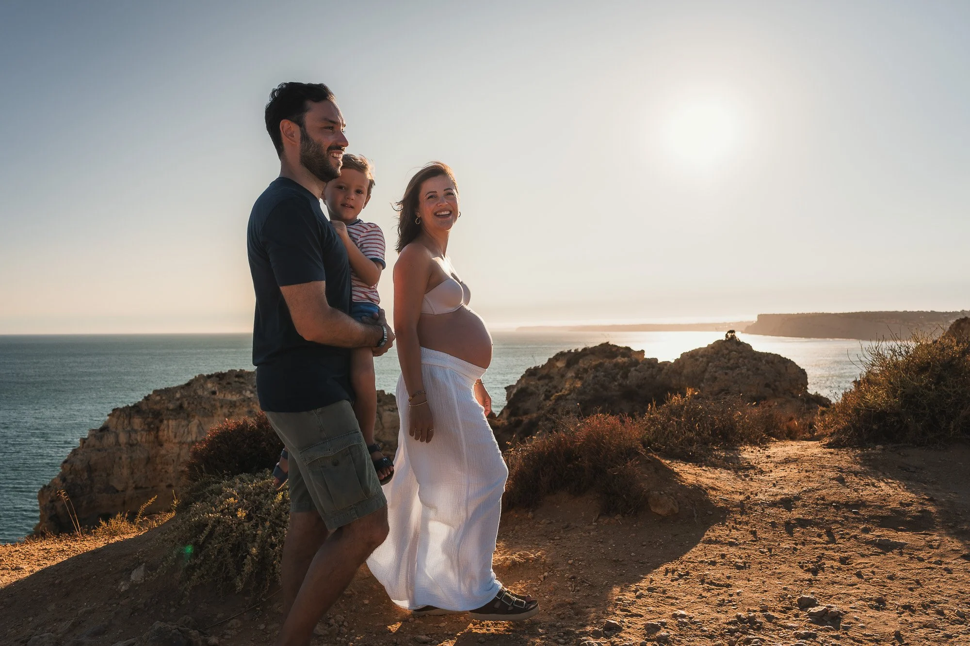 Couple and child capturing intimate moments during sunset on Ponta da Piedade cliffs, Lagos, Algarve.