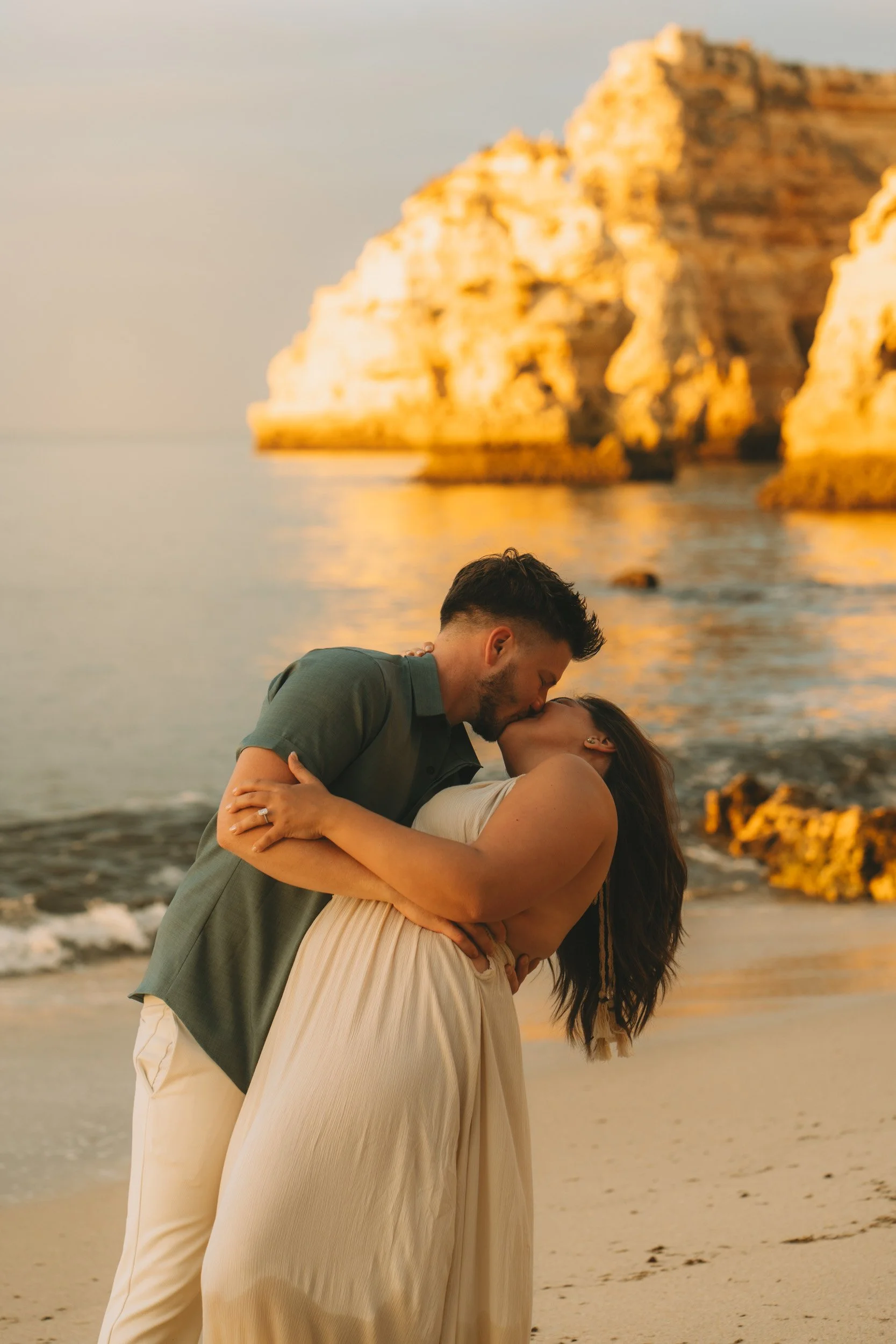 Romantic sunset kiss at Praia da Marinha captured with soft backlight and golden tones in Algarve Portugal.