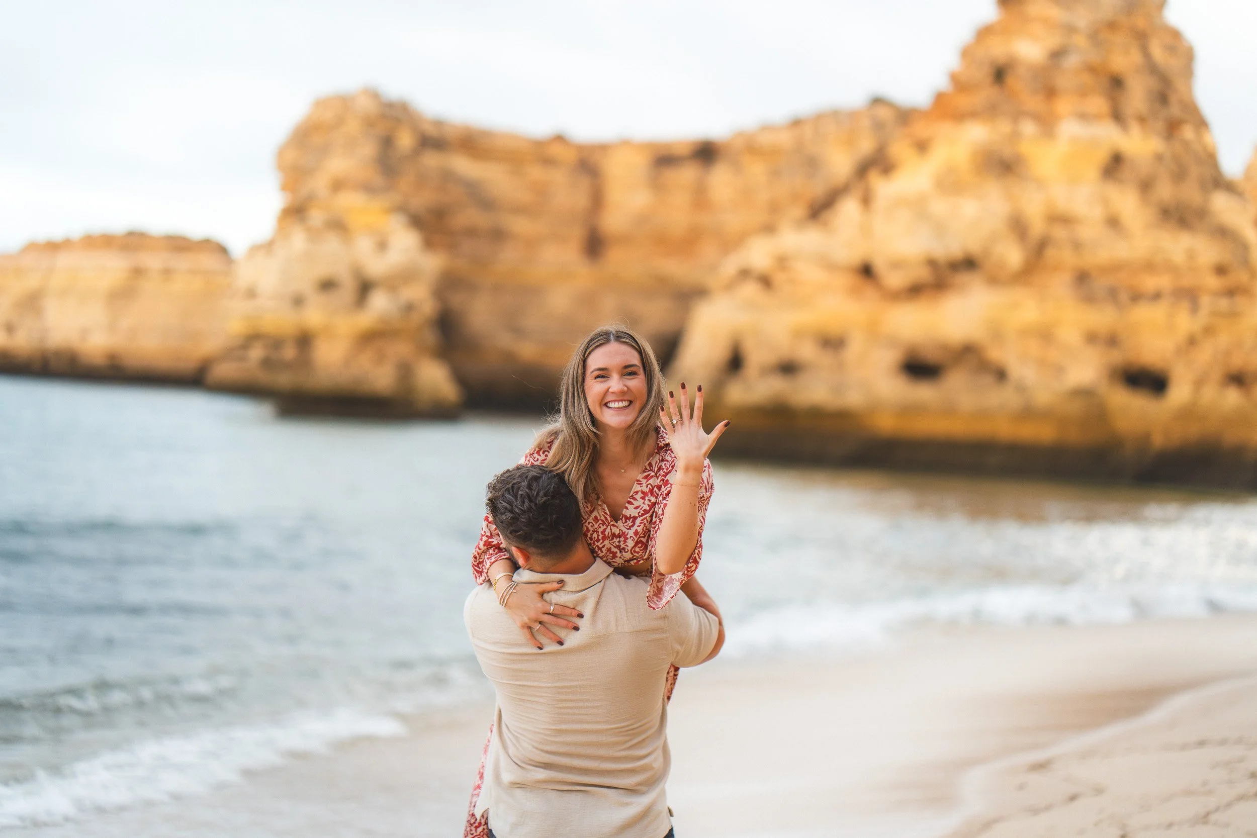 Proposal photoshoot in Praia da Marinha, in the Algarve. Women showing the ring after the propose.