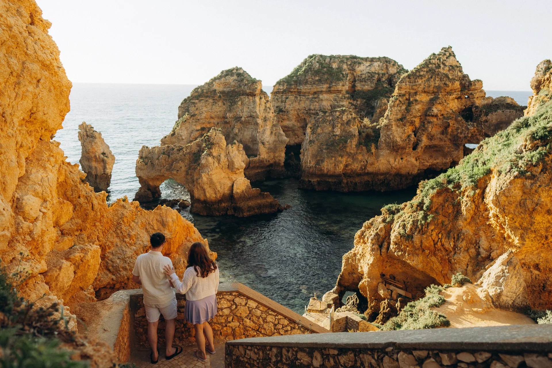 Intimate couple moment at Ponta da Piedade Lagos with warm golden light and ocean backdrop