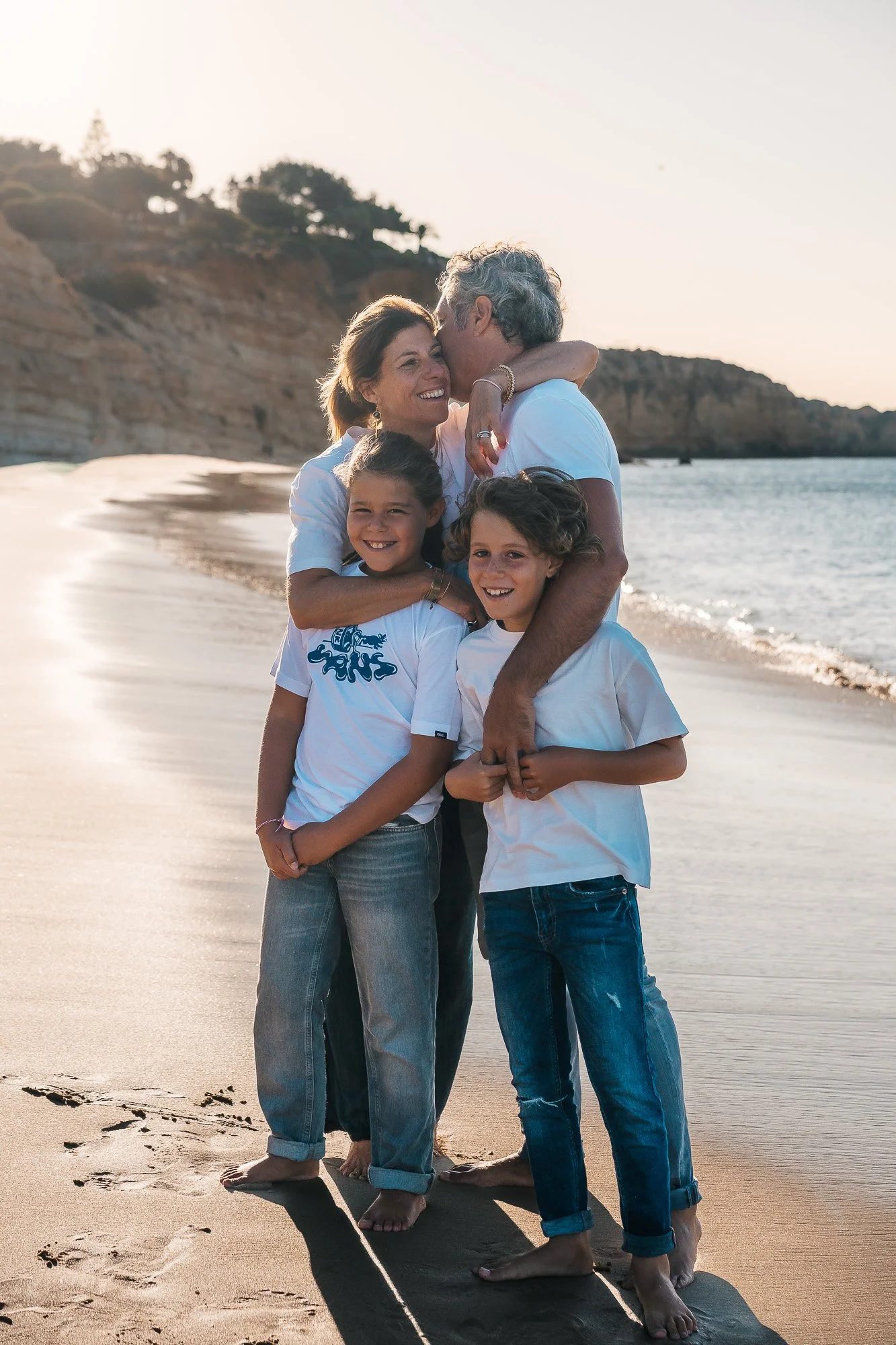 Parents with two children playing on Porto de Mós beach, Lagos, Algarve.