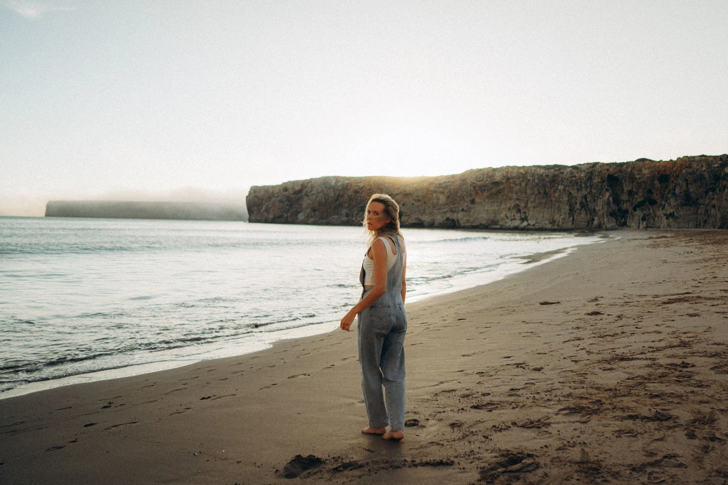 Wide cinematic portrait shot on Algarve shoreline — environmental storytelling photography