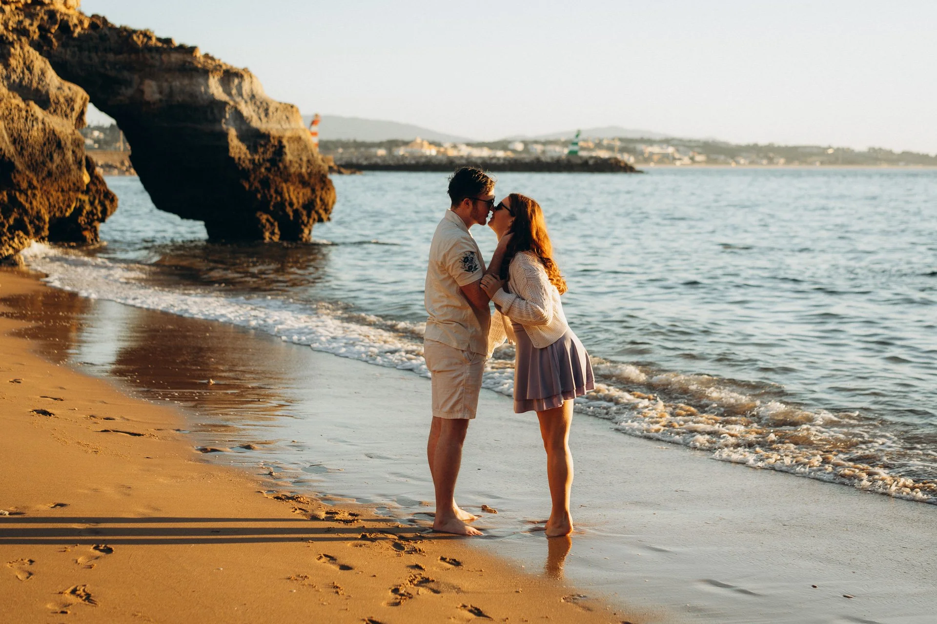 Couple kissing on the beach at Praia dos Estudiantes during golden hour photoshoot in the Algarve