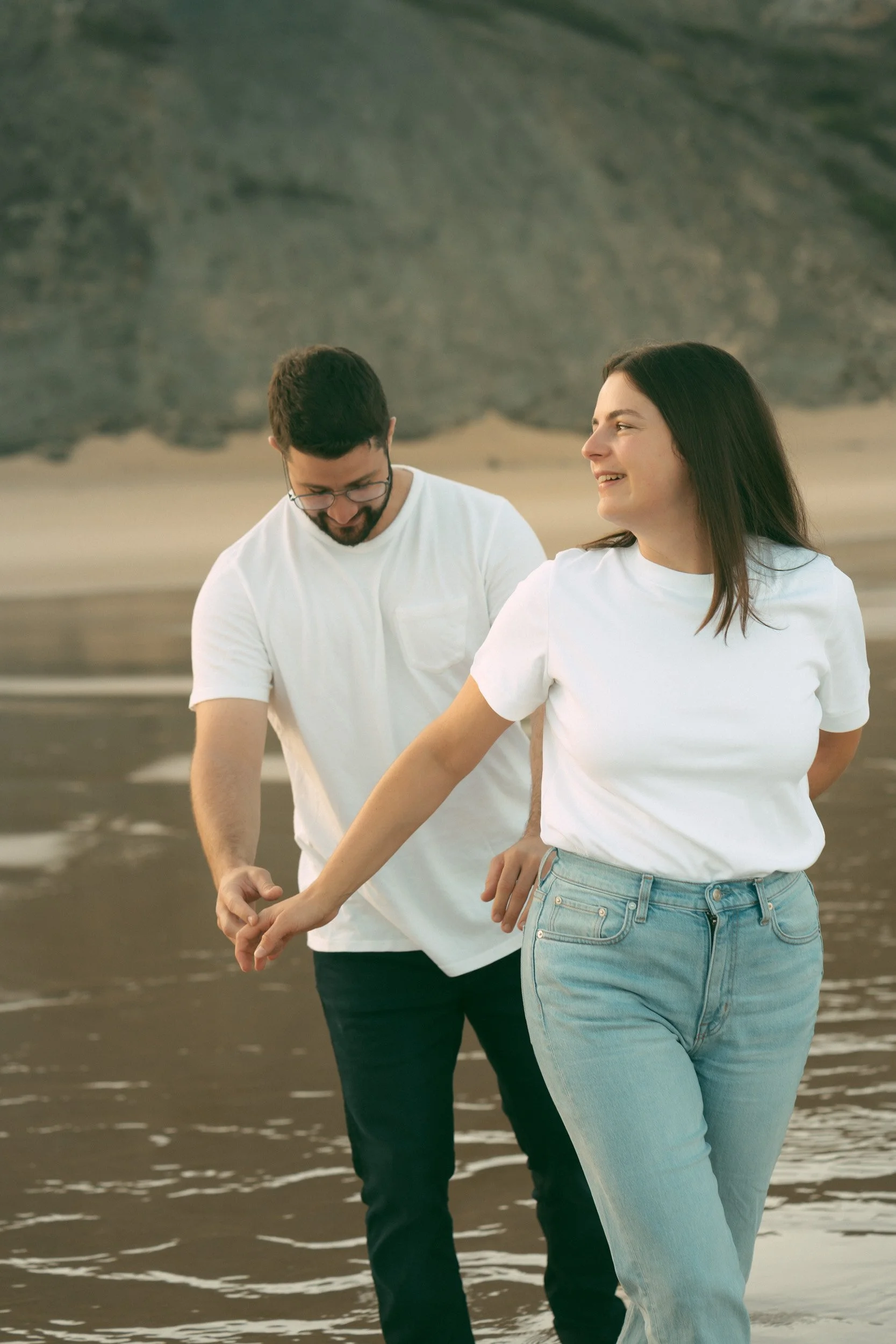 Close emotional portrait of a couple holding hands during a golden hour beach session in the Algarve. Intimate lifestyle couple photography highlighting authentic connection and soft natural light.