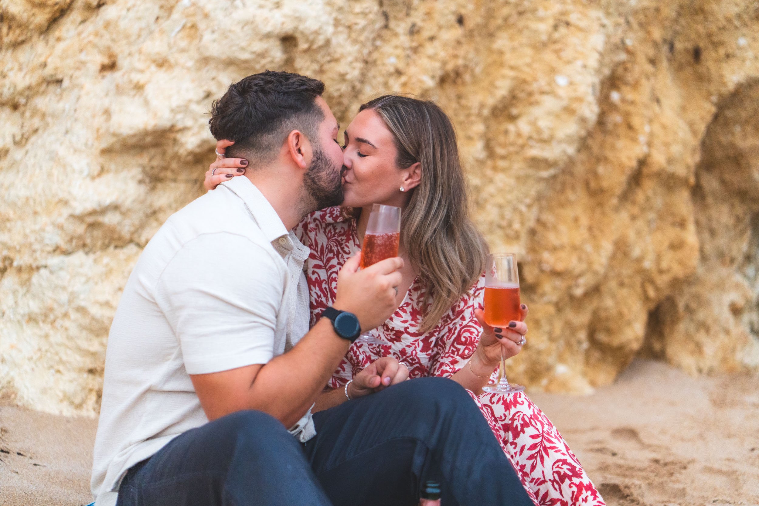 Close-up of a couple celebrating their engagement with champagne during a Praia da Marinha proposal photoshoot in the Algarve.