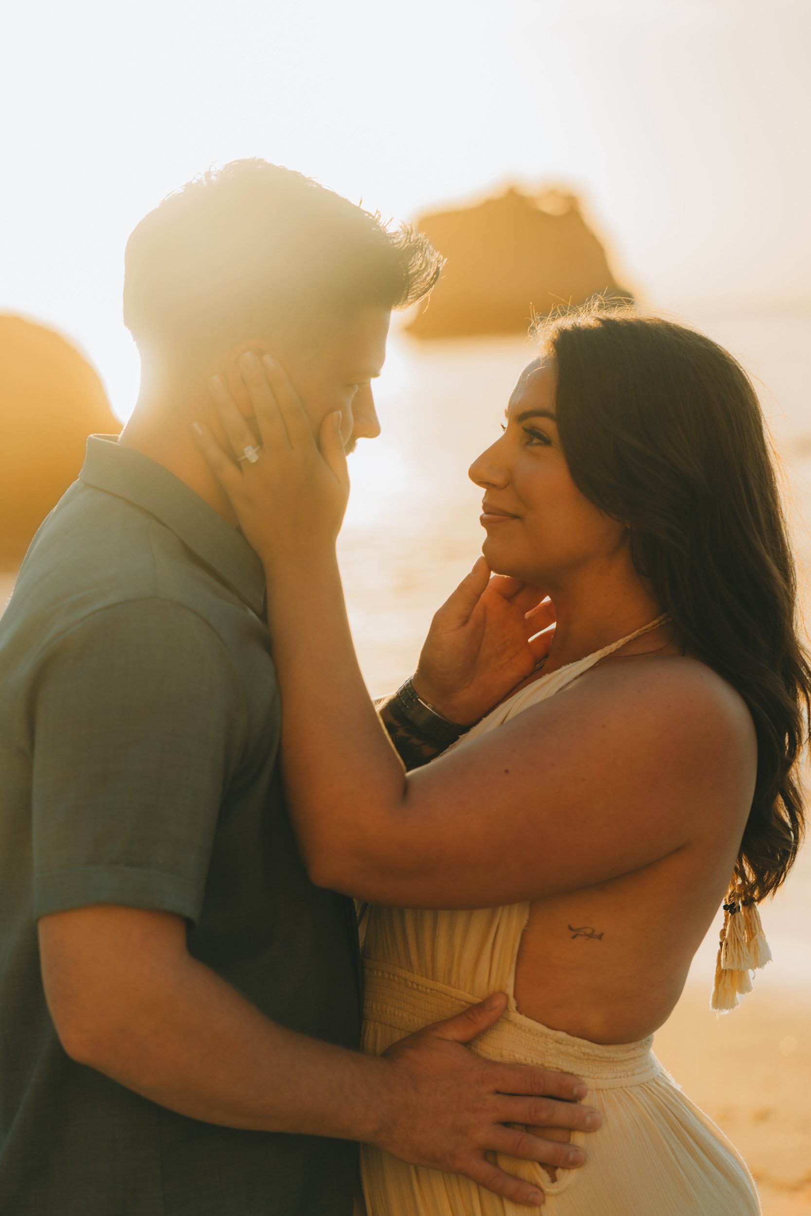 Romantic couple portrait at Praia da Marinha cliffs during sunset engagement session in Algarve Portugal.