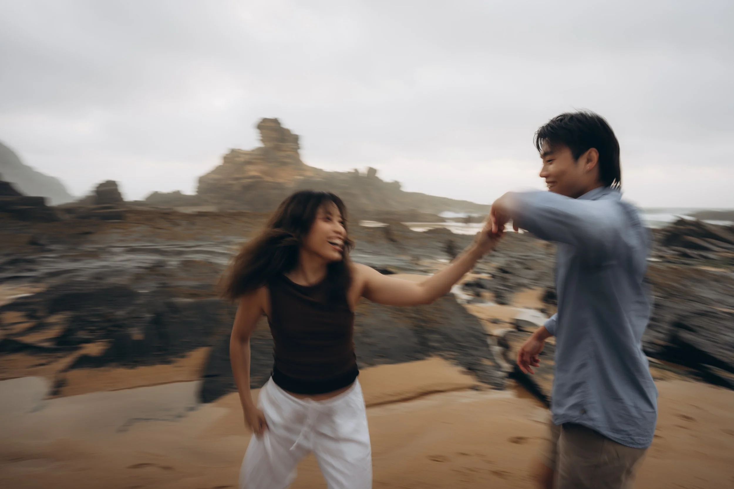 Wide environmental shot of a proposal photoshoot at Praia do Castelejo, Algarve, emphasizing location atmosphere and cinematic coastal scenery.