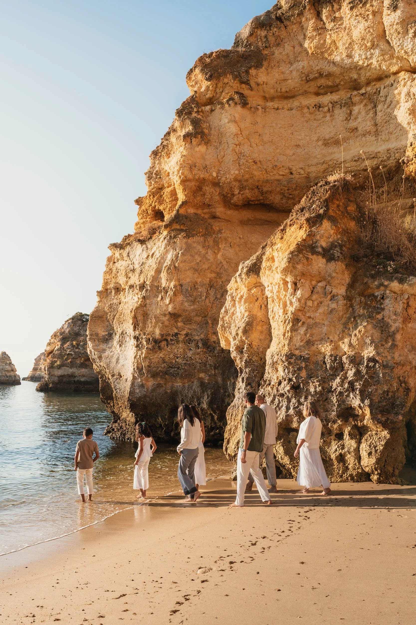 Family exploring the cliffs of Praia do Camilo during a sunrise photoshoot in Lagos Algarve.