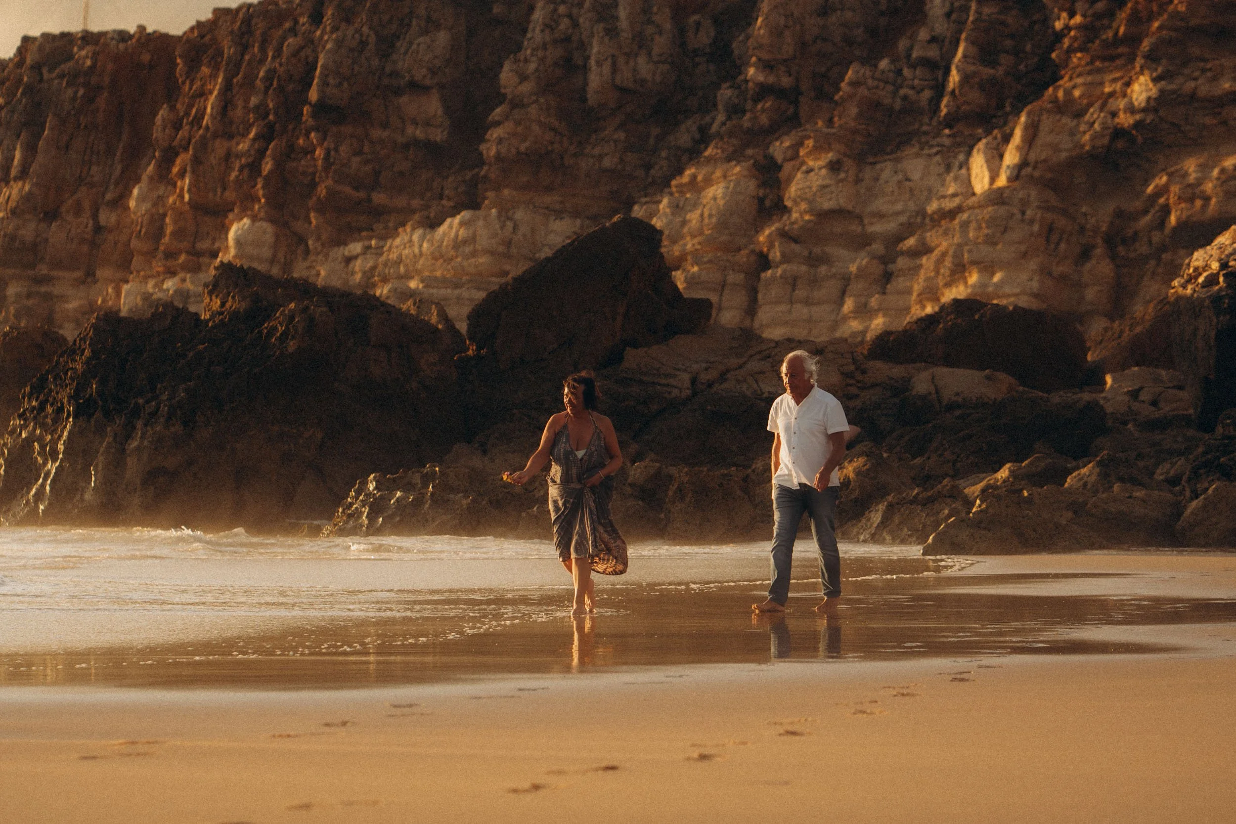 Sunset couple walk along the Algarve coast at Praia do Tonel, photographed in warm golden light.