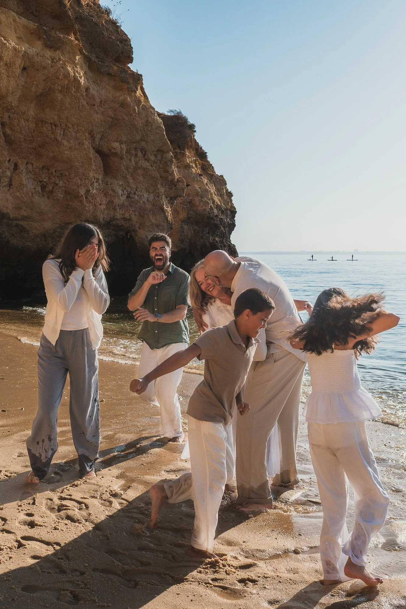 An extended family of 7 playing by the ocean at Praia do Camilo, Lagos, Algarve.