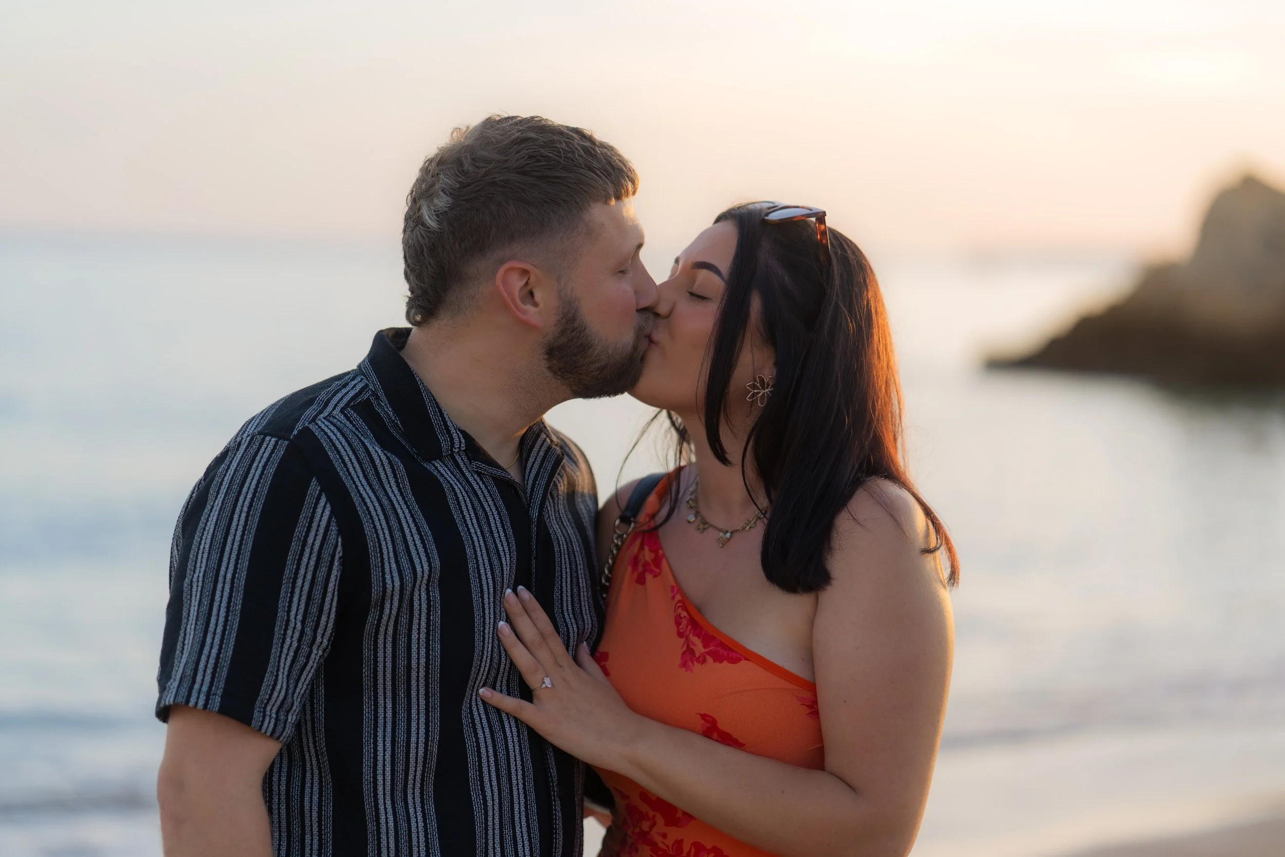 Just after she said yes — a spontaneous kiss framed by warm sunset light along the Algarve coastline. Natural reactions, real emotion, no staging.