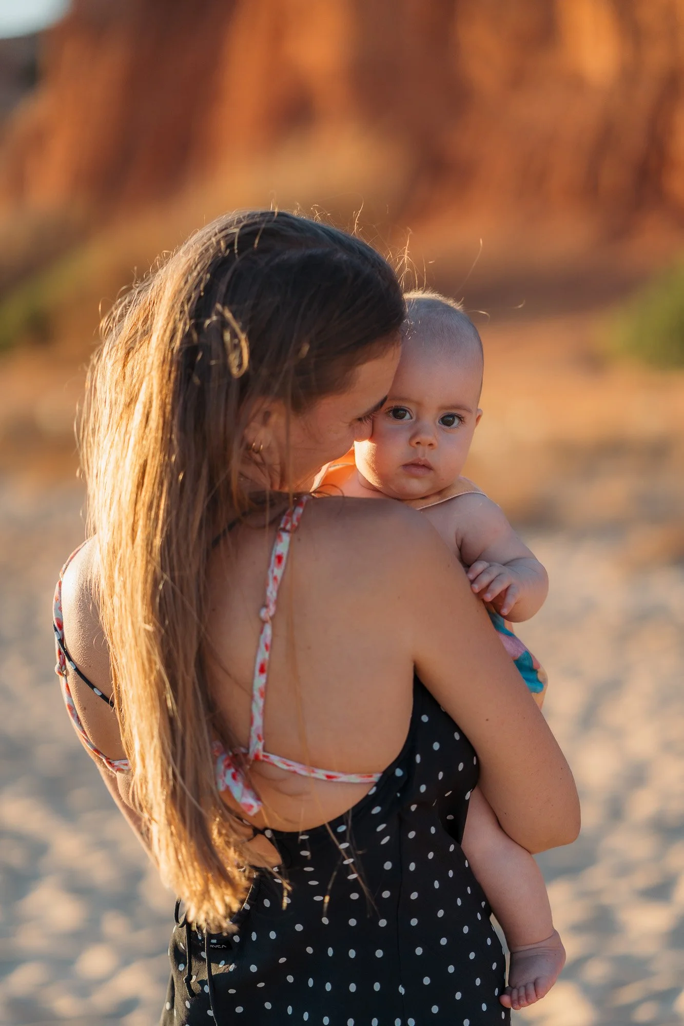 Family of 4 enjoying candid moments on the Algarve cliffs with the sea in the background.