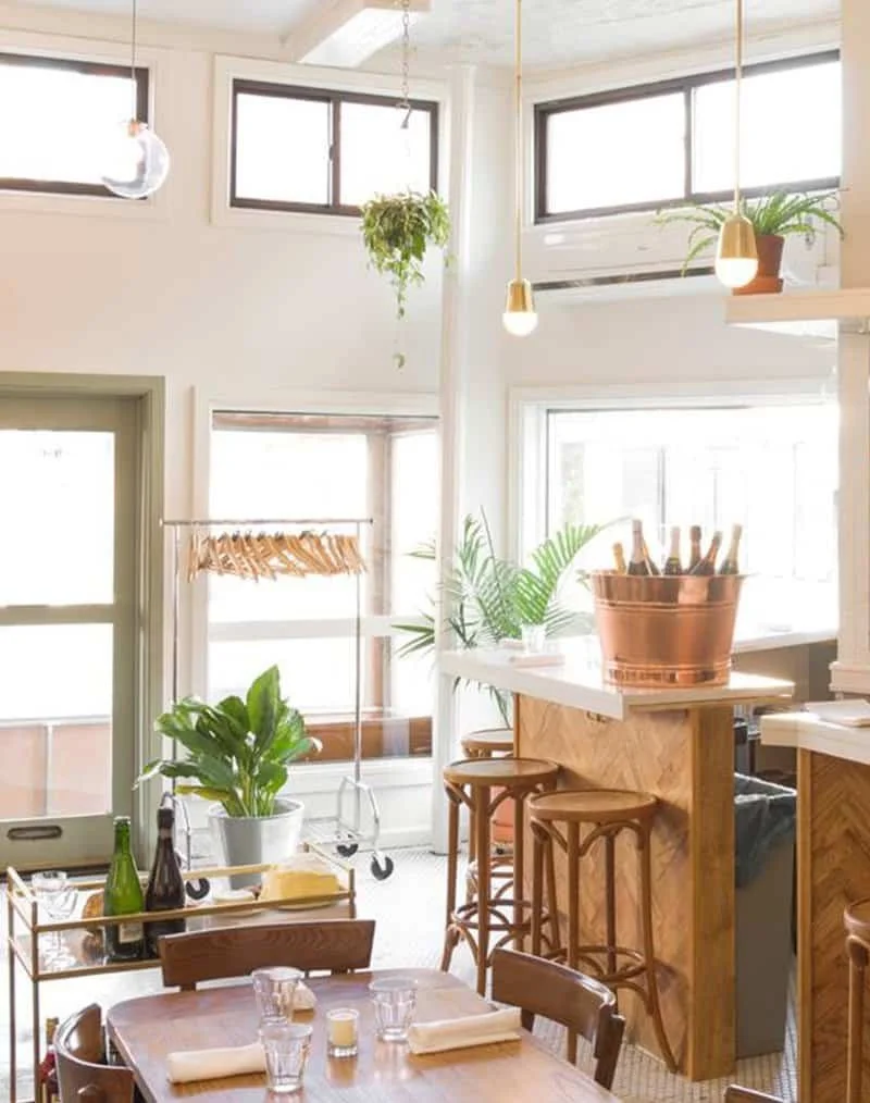 Bright brunch area with wooden accents, plants, and champagne station | The Morris Project