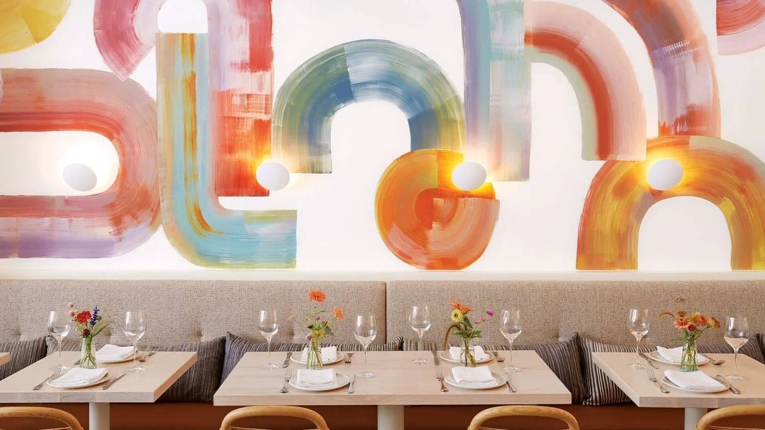 Dining area with colorful abstract wall art and floral table accents | The Morris Project