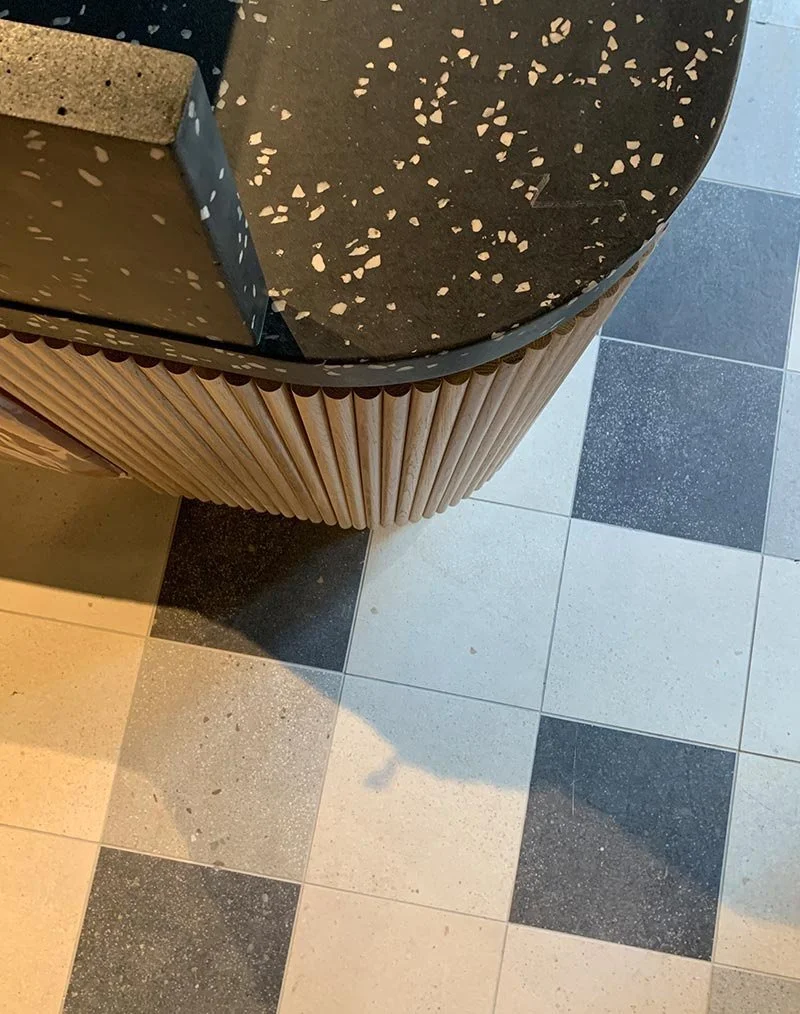 Terrazzo countertop and wood paneling detail on checkered flooring | The Morris Project