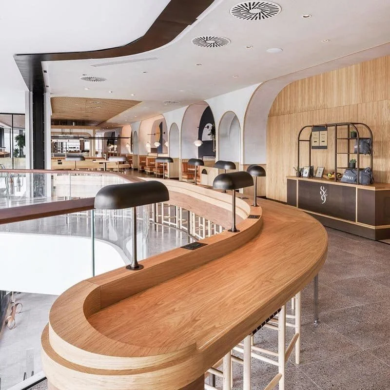 Modern wood bar with sleek lighting and arched walls in open space | The Morris Project