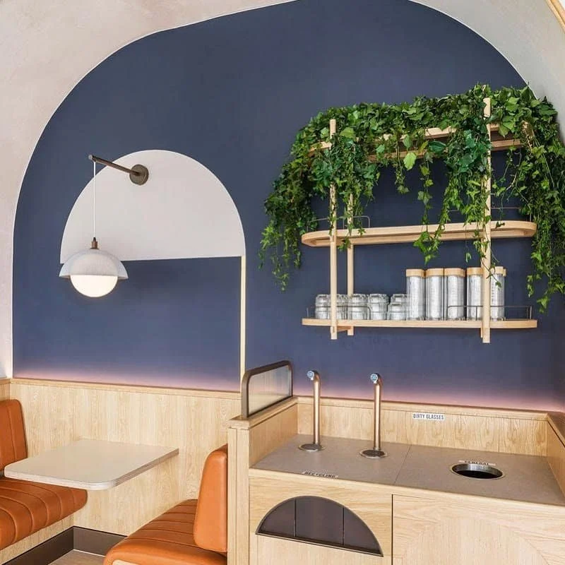 Modern booth design with navy accents and hanging greenery | The Morris Project