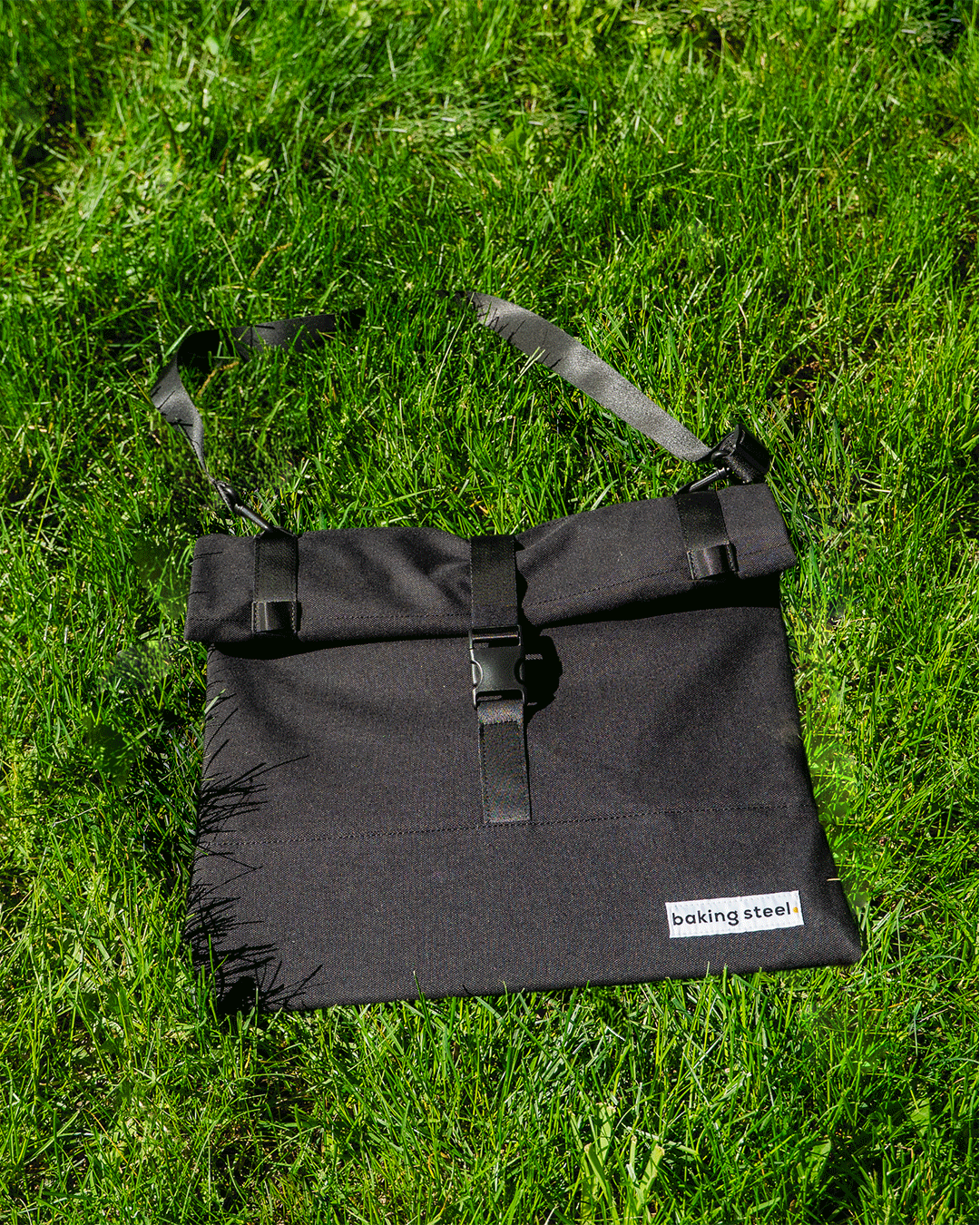 GIF of black bag rolling up and down on green grass