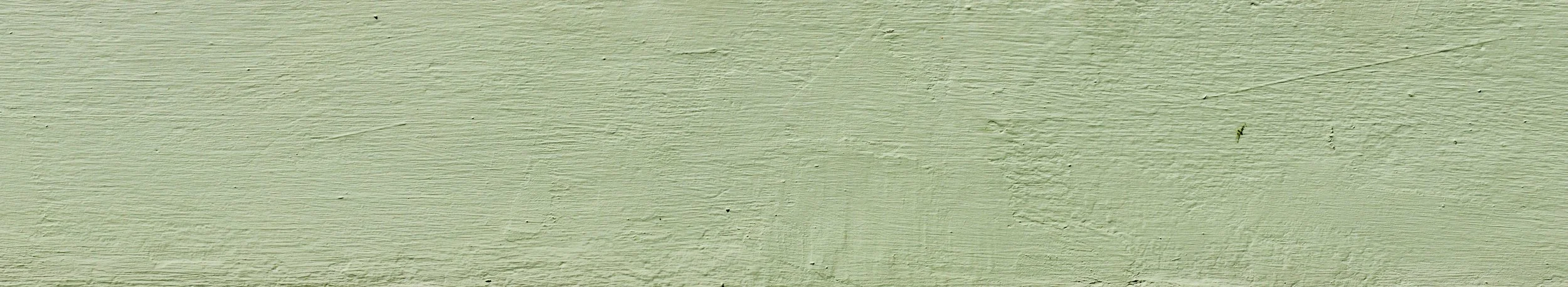 Close-up of a painted wooden surface in light green color.