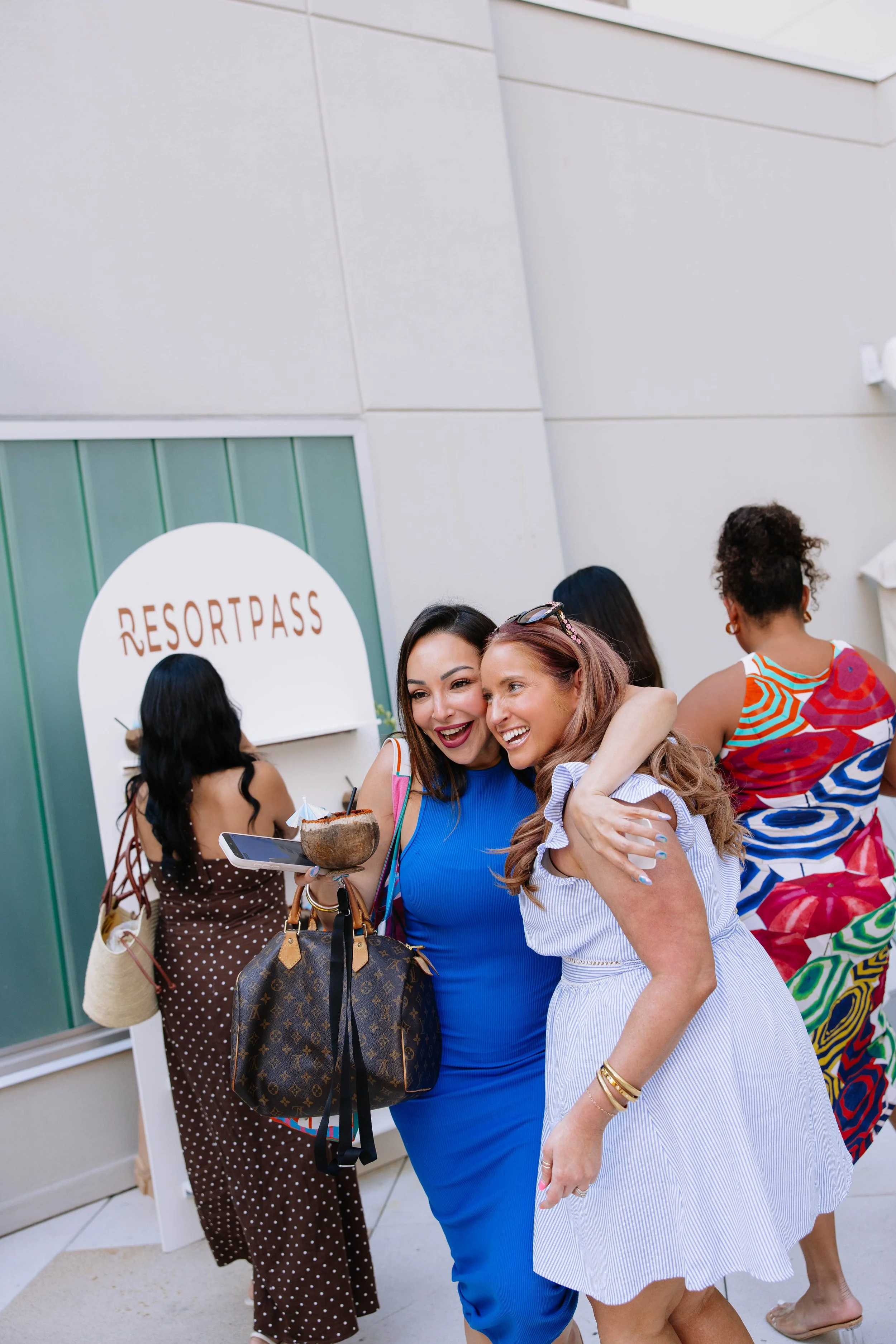 Resort Pass influencers hugging and smiling with coconut drink