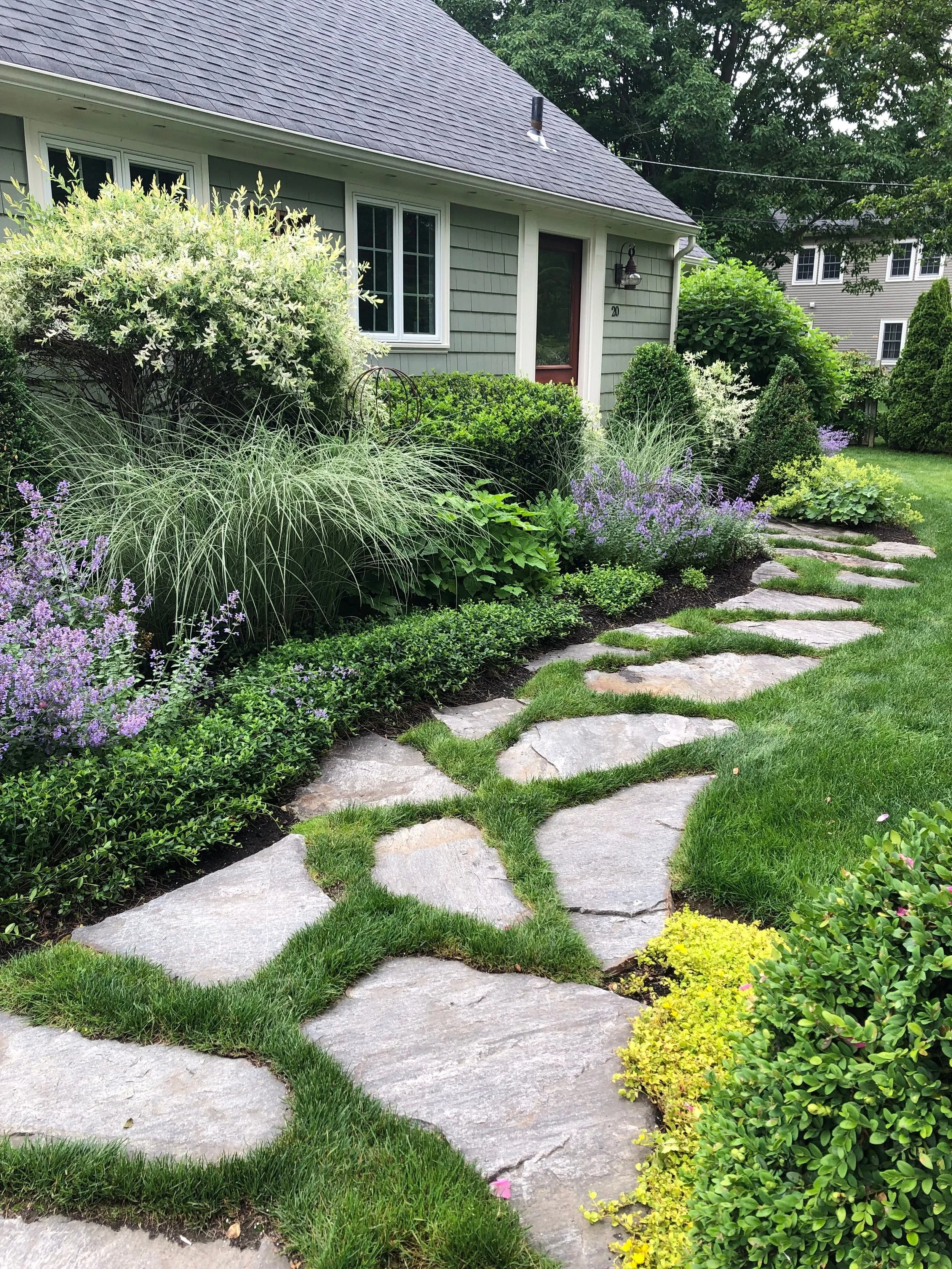 Large format natural stone pavers with a grass joint creates an informal, cottage style entry.