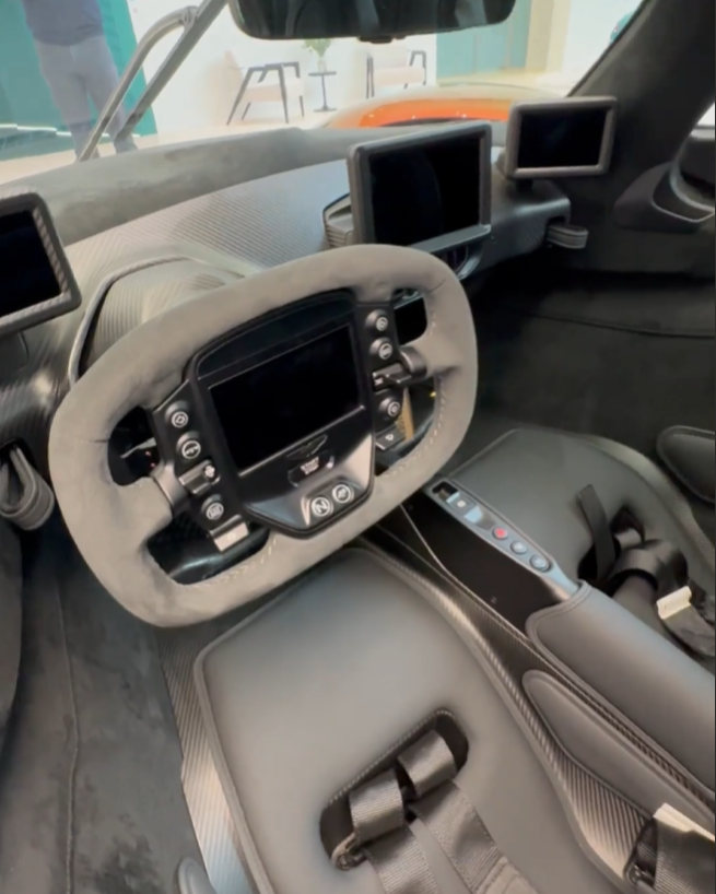 Interior cockpit view of an Aston Martin hypercar highlighting driver-focused engineering and precision design