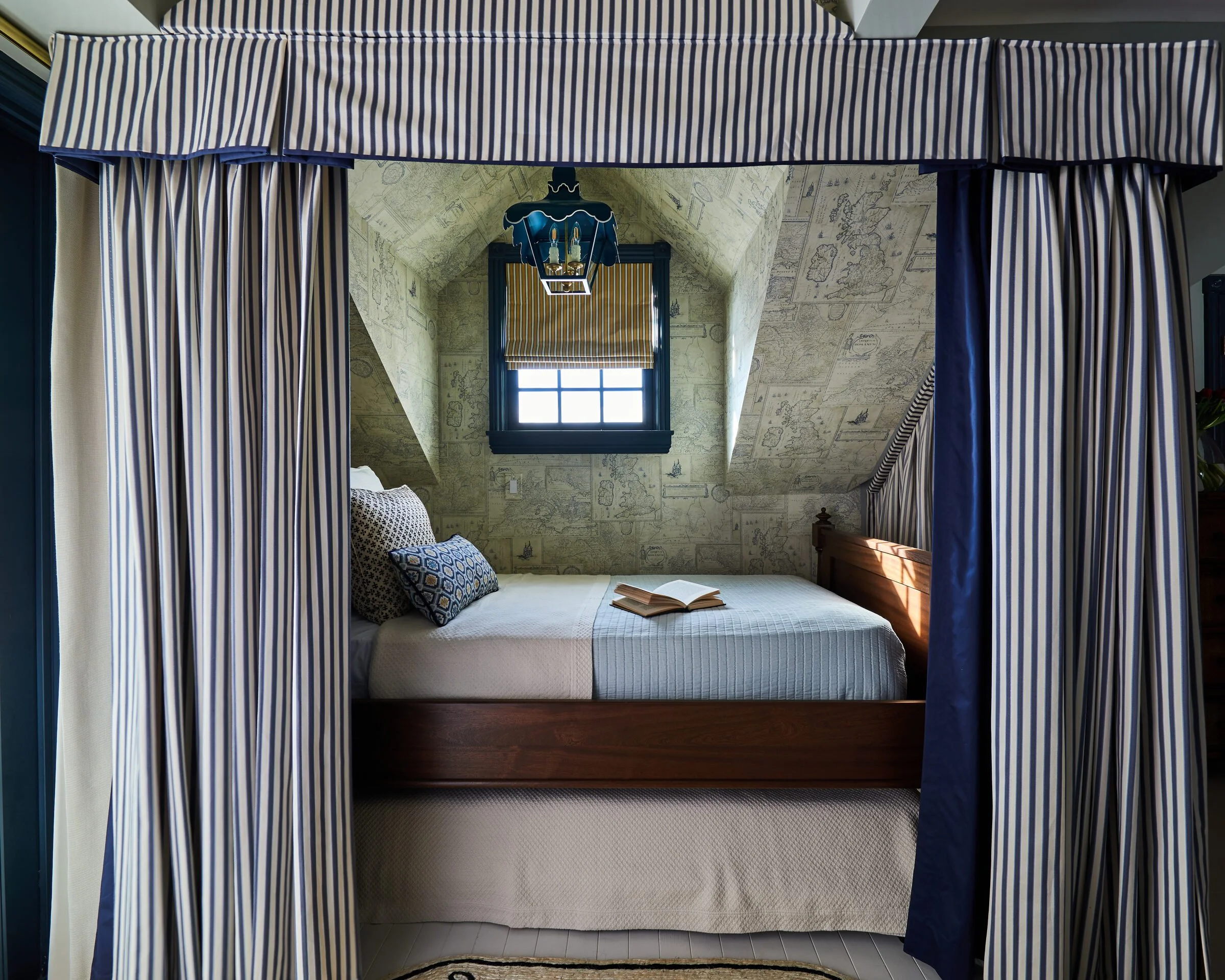 Striped canopy bed in an attic bedroom designed by Tartan and Toile Interior Design
