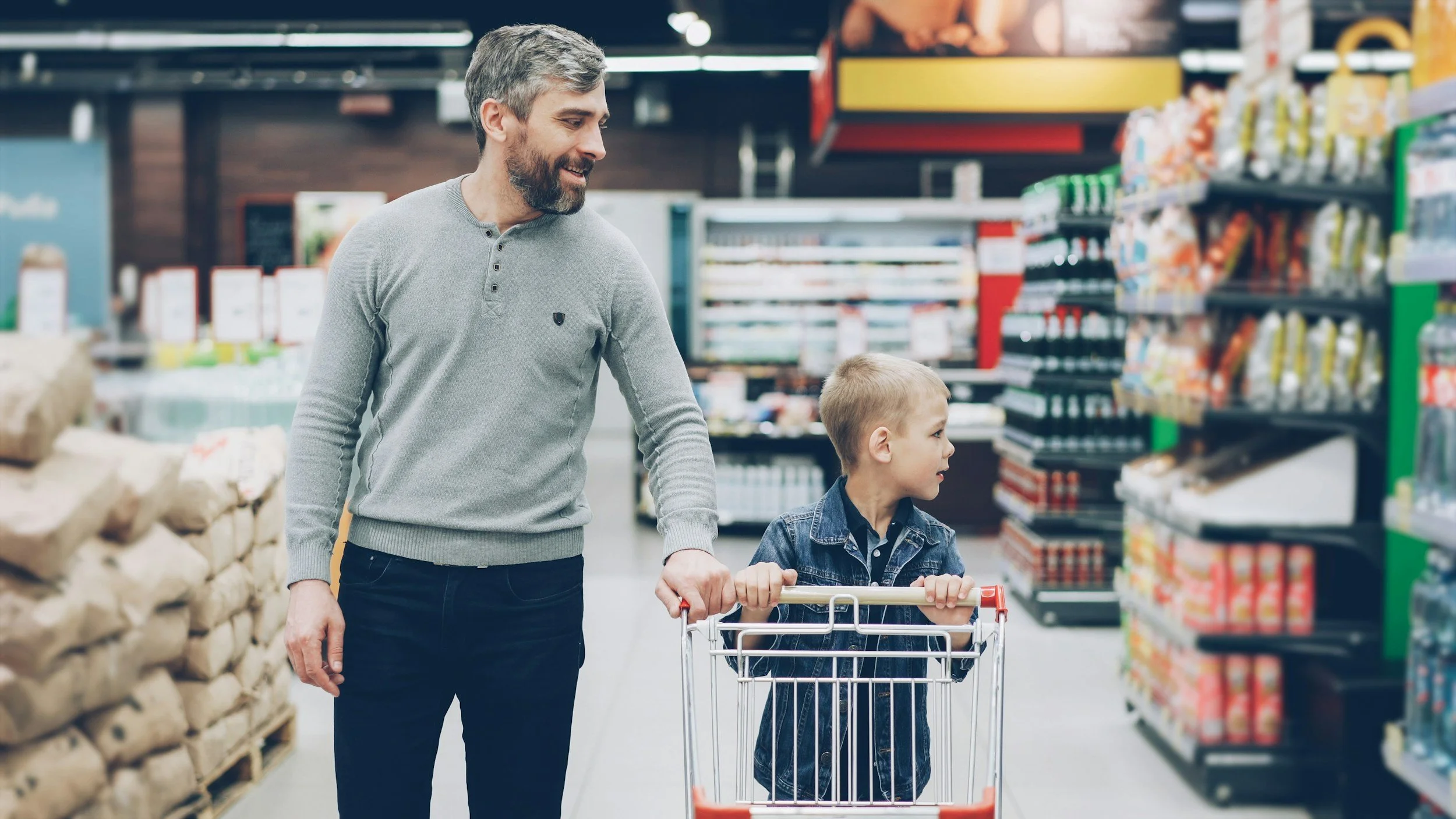 Parent and child practicing life skills in a grocery store to support community participation and independence through occupational therapy
