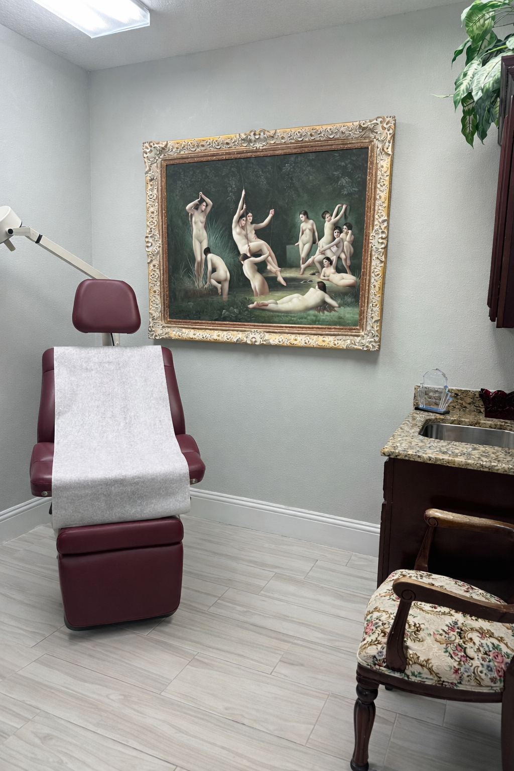 An aesthetic therapy office with a treatment chair and art on the wall.