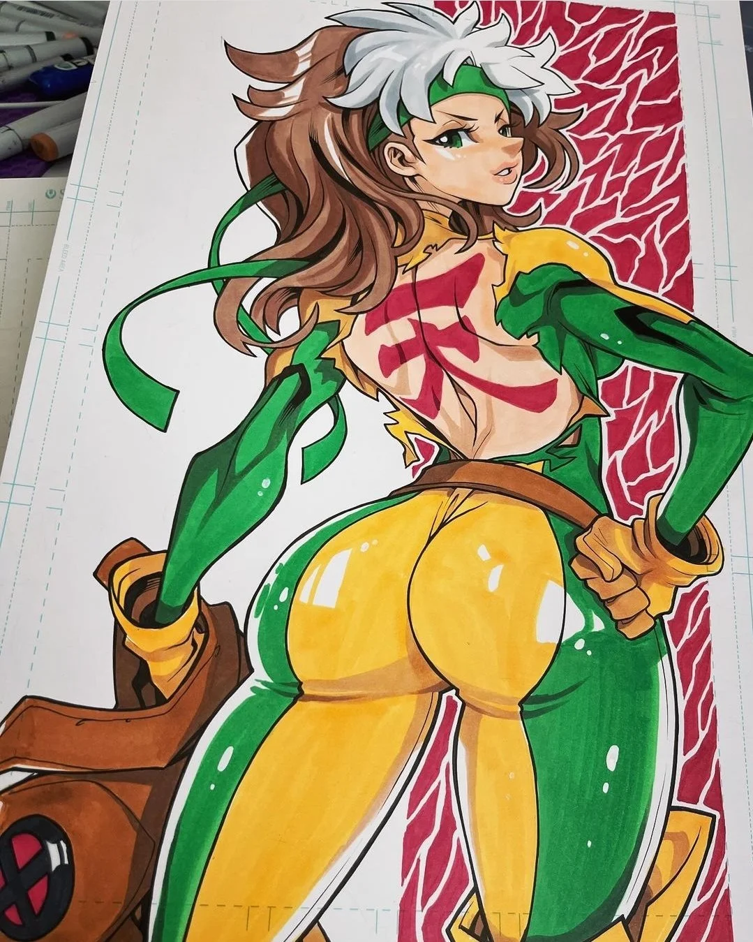 A colorful illustration of a female superhero with long brown hair, green gloves and boots, yellow pants, and a green and yellow costume. She is posed confidently with her back turned, showing the superhero emblem on her chest, with a background of red lightning.