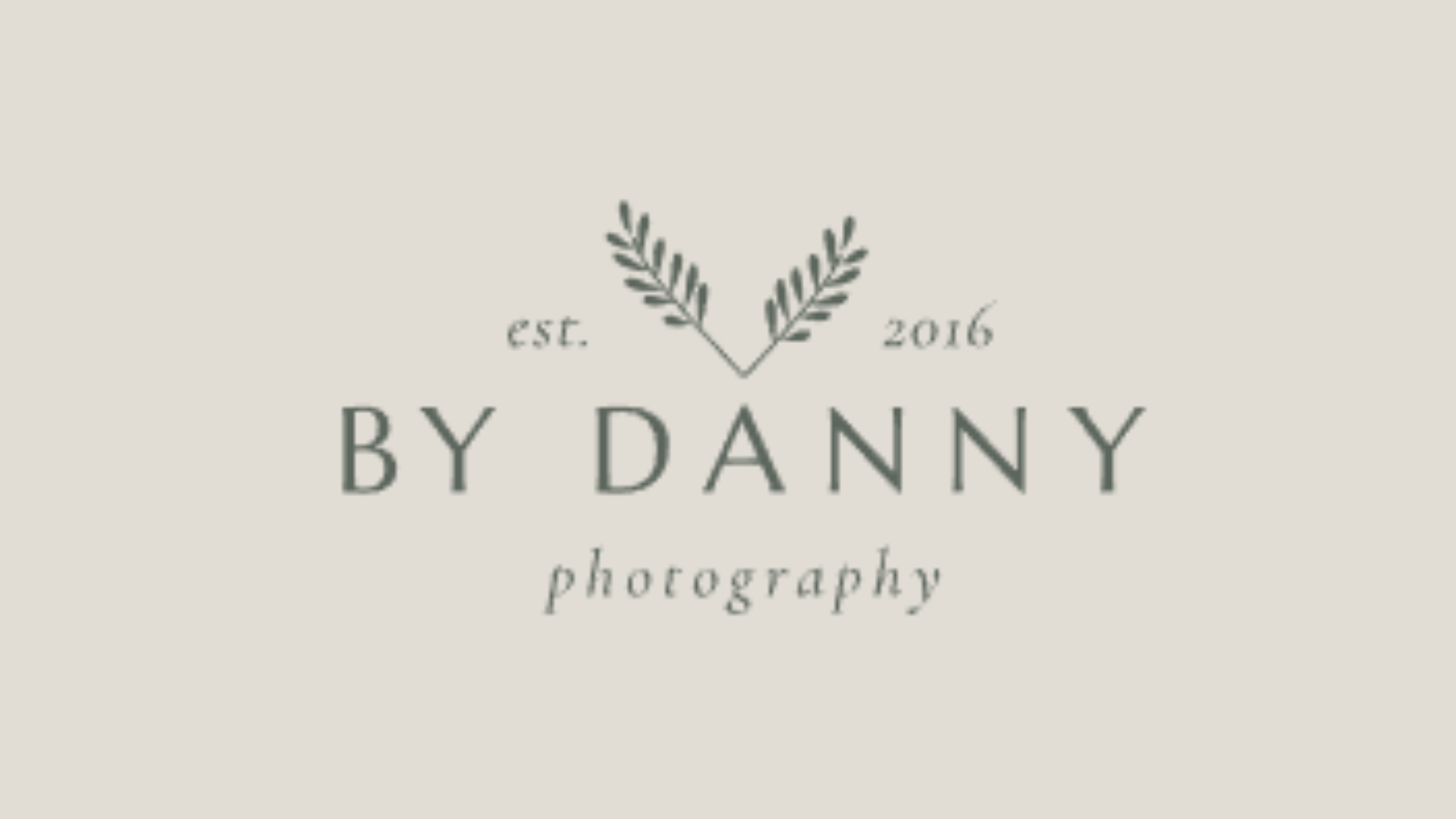 A logo for By Danny Photography with two olive branches crossing above the text, 'est. 2016,' and the words 'BY DANNY' in large font with 'photography' below in smaller cursive.