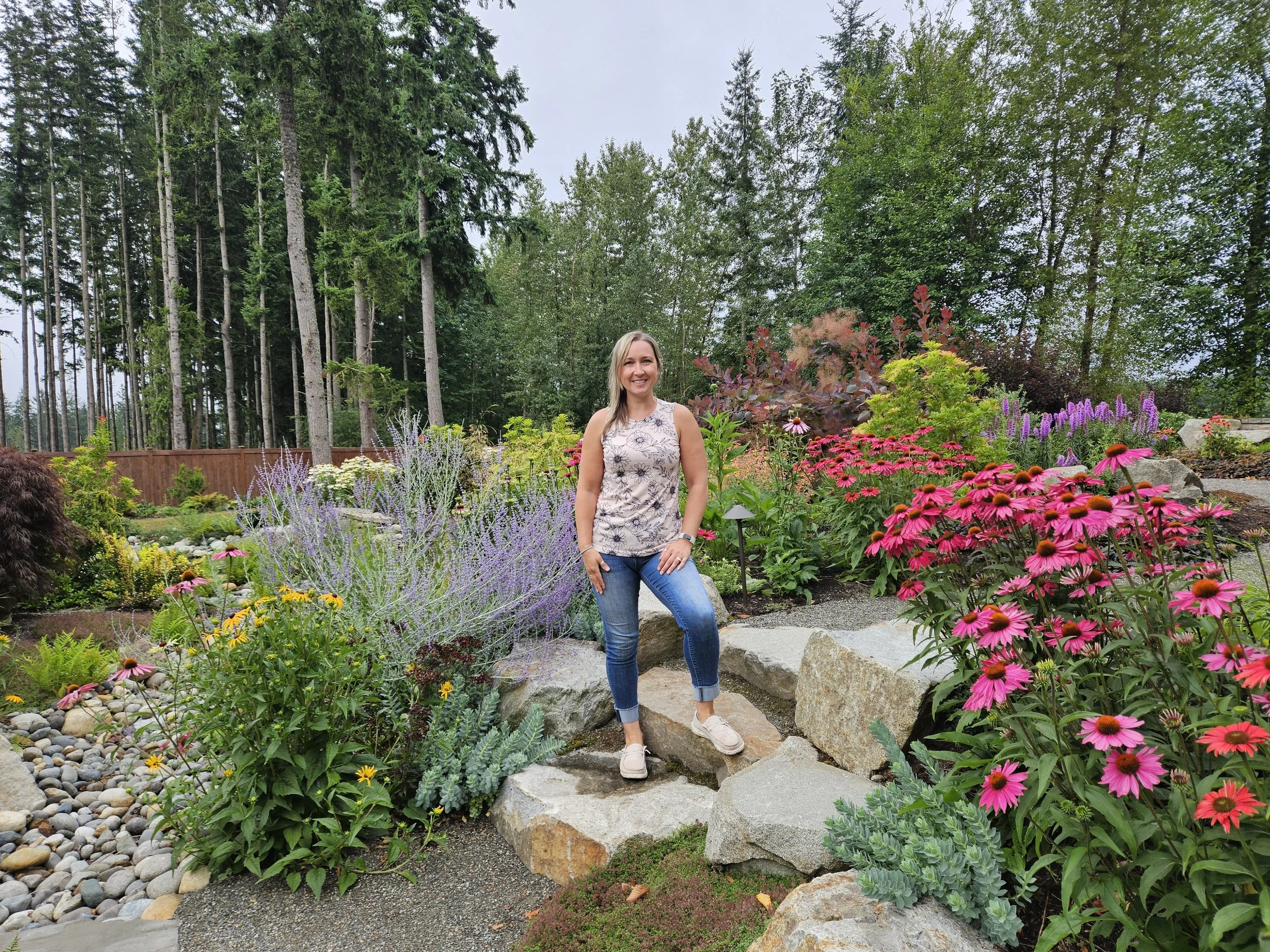woman standing on a rock in a lush landscape