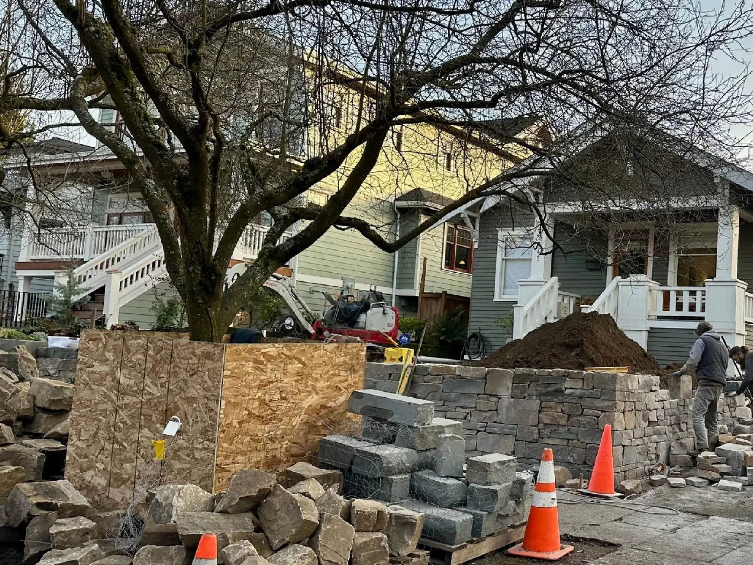 Front yard stone wall being built by two men
