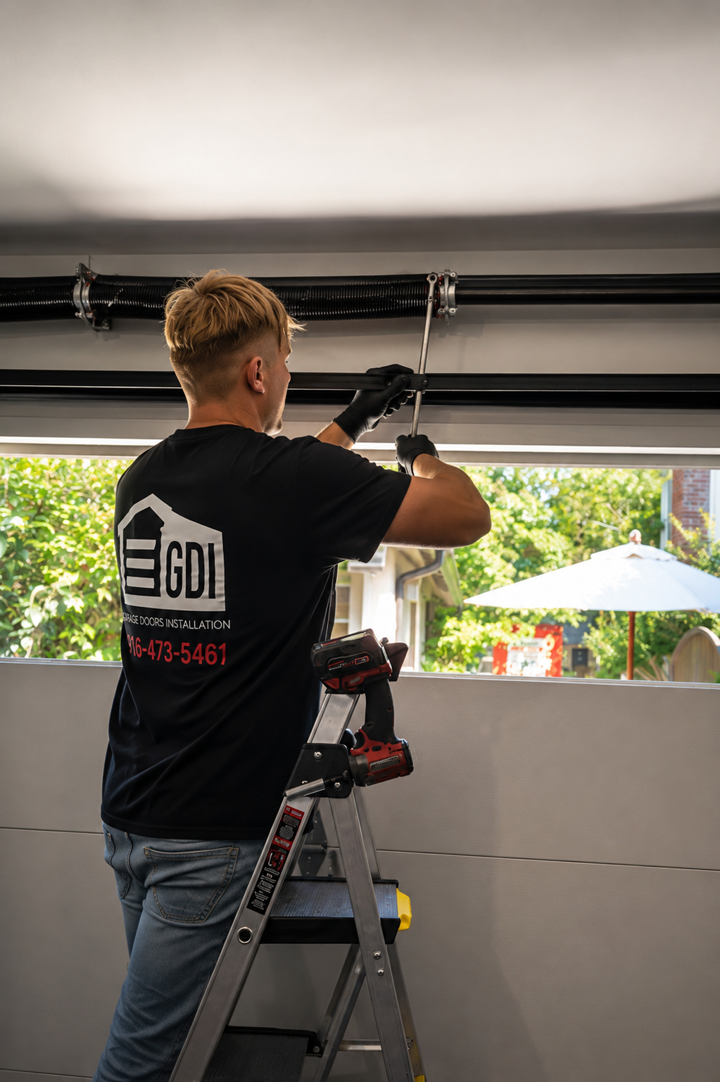 A technician on a ladder installing or repairing a garage door spring with Garage Doors Installation in Sacramento, CA