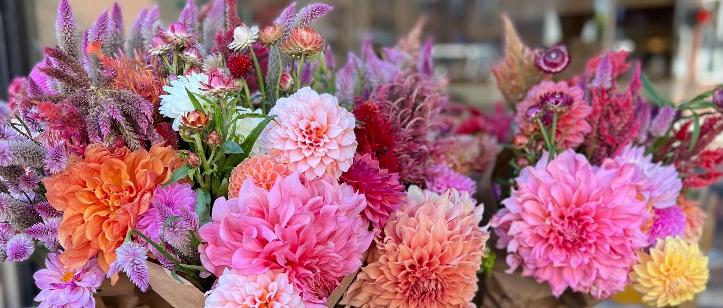 A vibrant bouquet of pink, orange, purple, and white flowers in a basket.