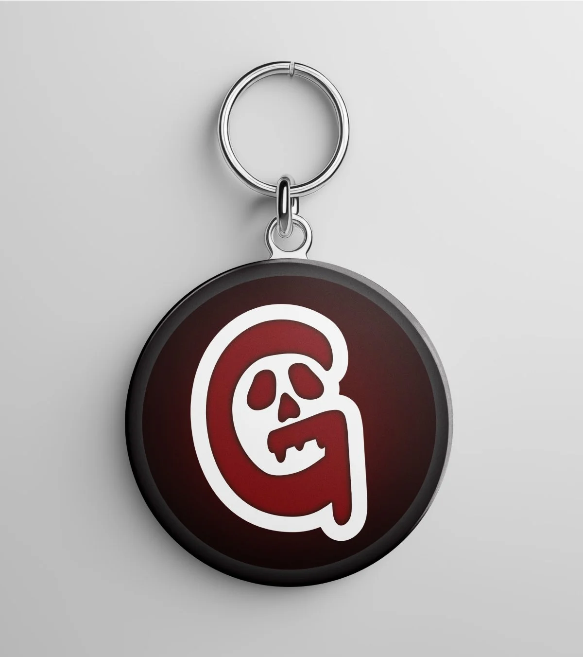 red and black round keychain with grim alley's skull logo.