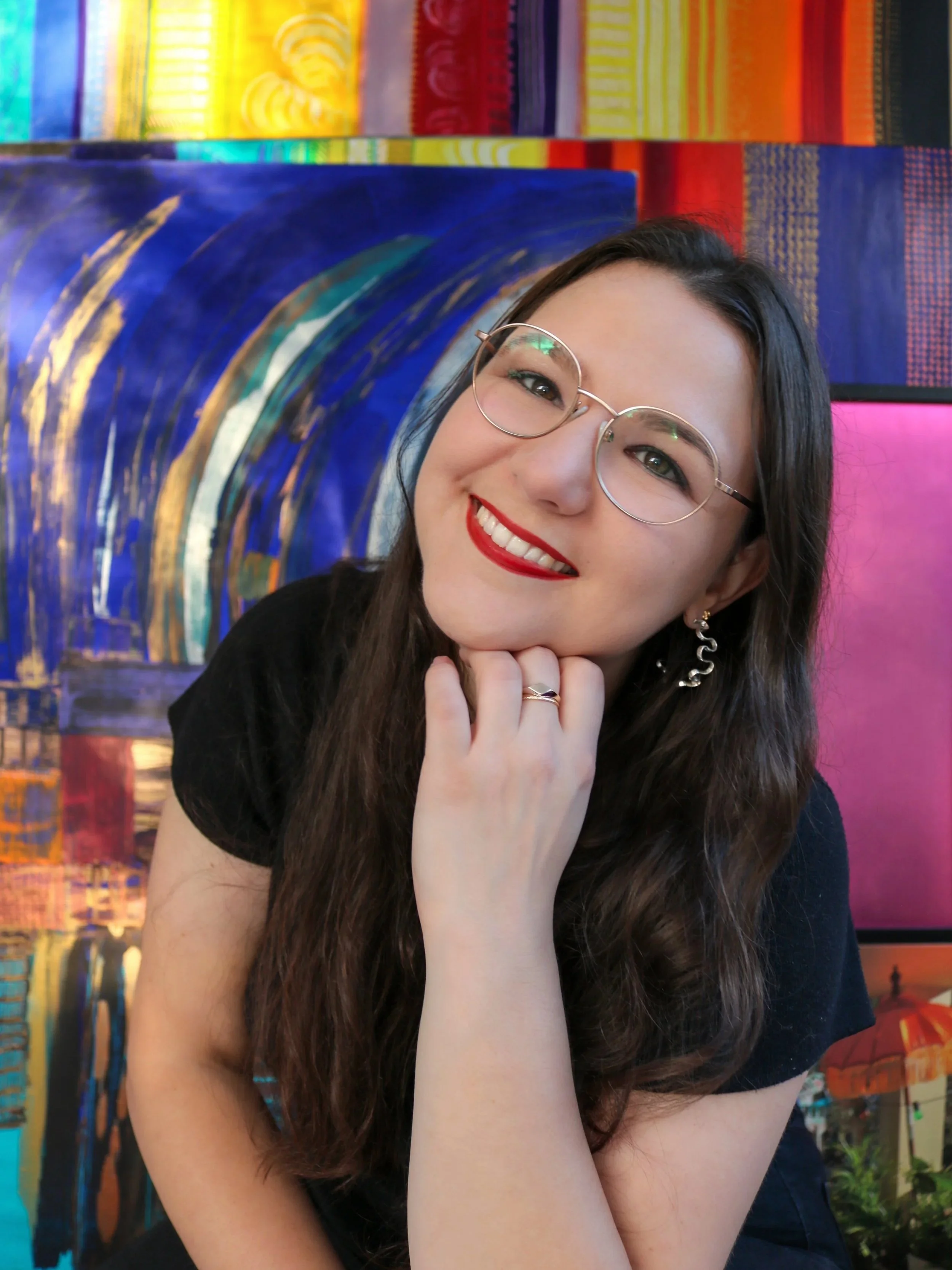 Portrait of Isabella Ceccato, jewellery designer and founder of Isabella Ceccato Design, smiling in front of colourful artwork