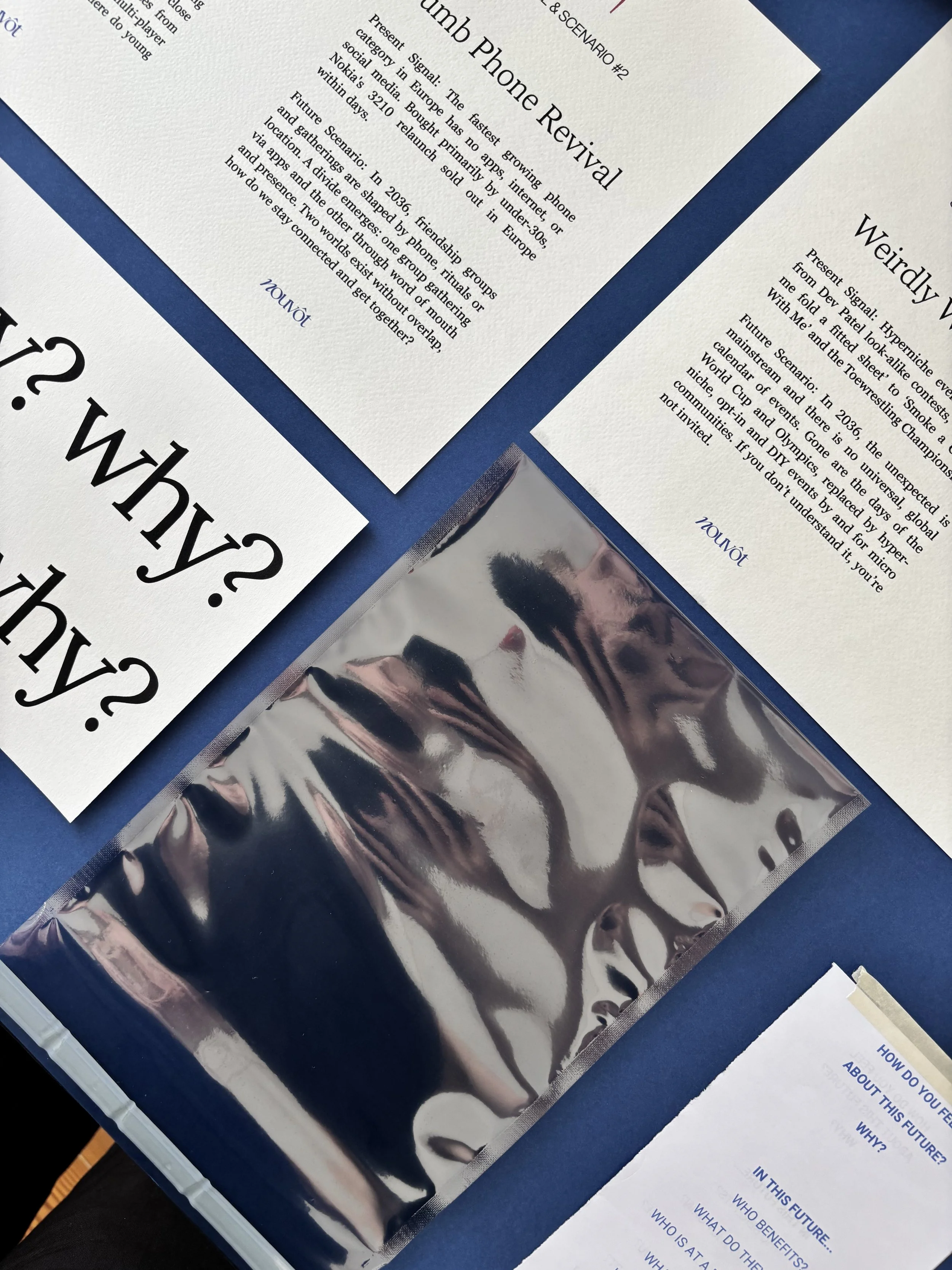 Close-up view of printed sheets of paper with text and some reflective foil material on a blue surface.