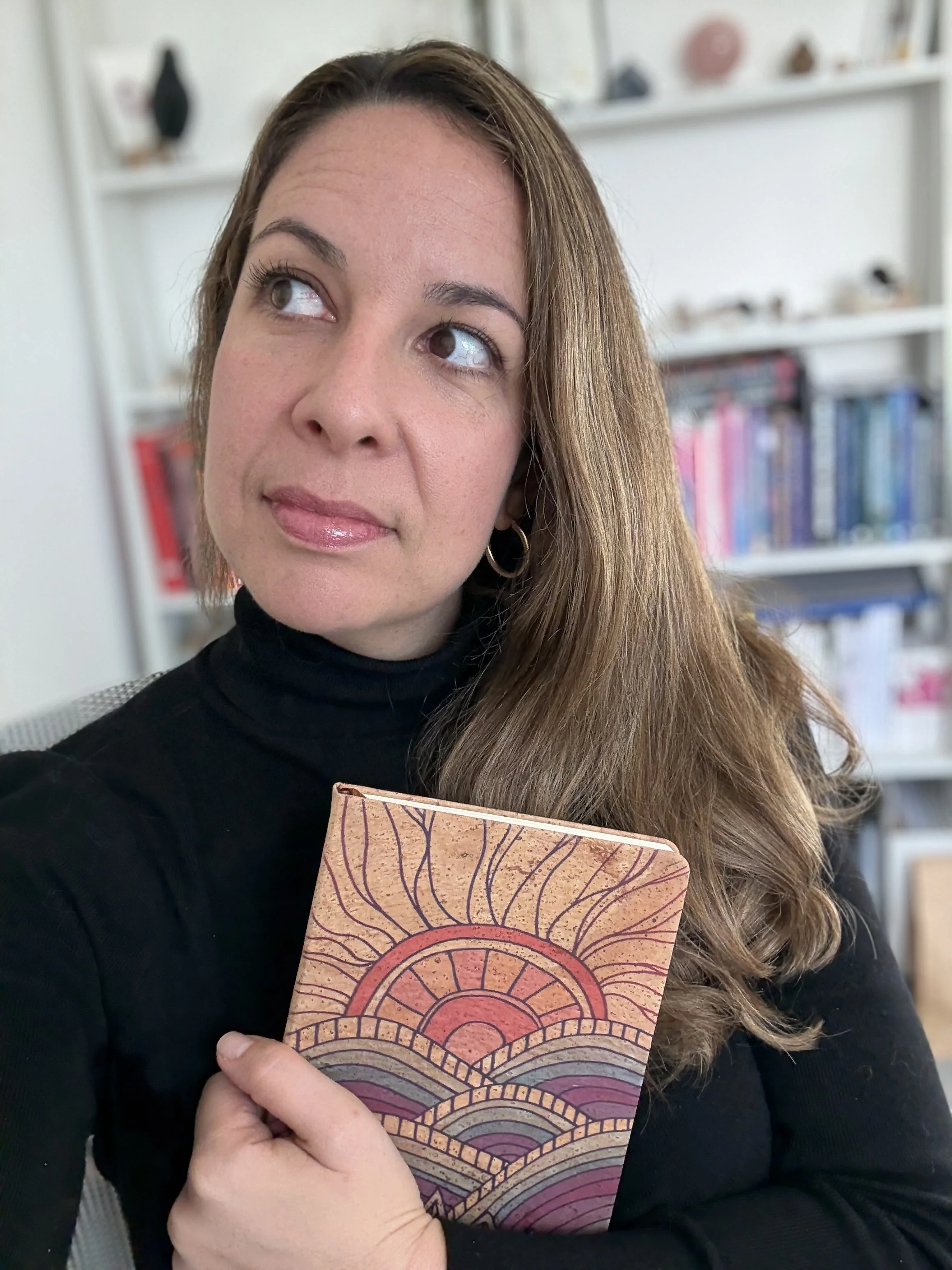 Woman with a notebook contemplating what she wants in 2026.