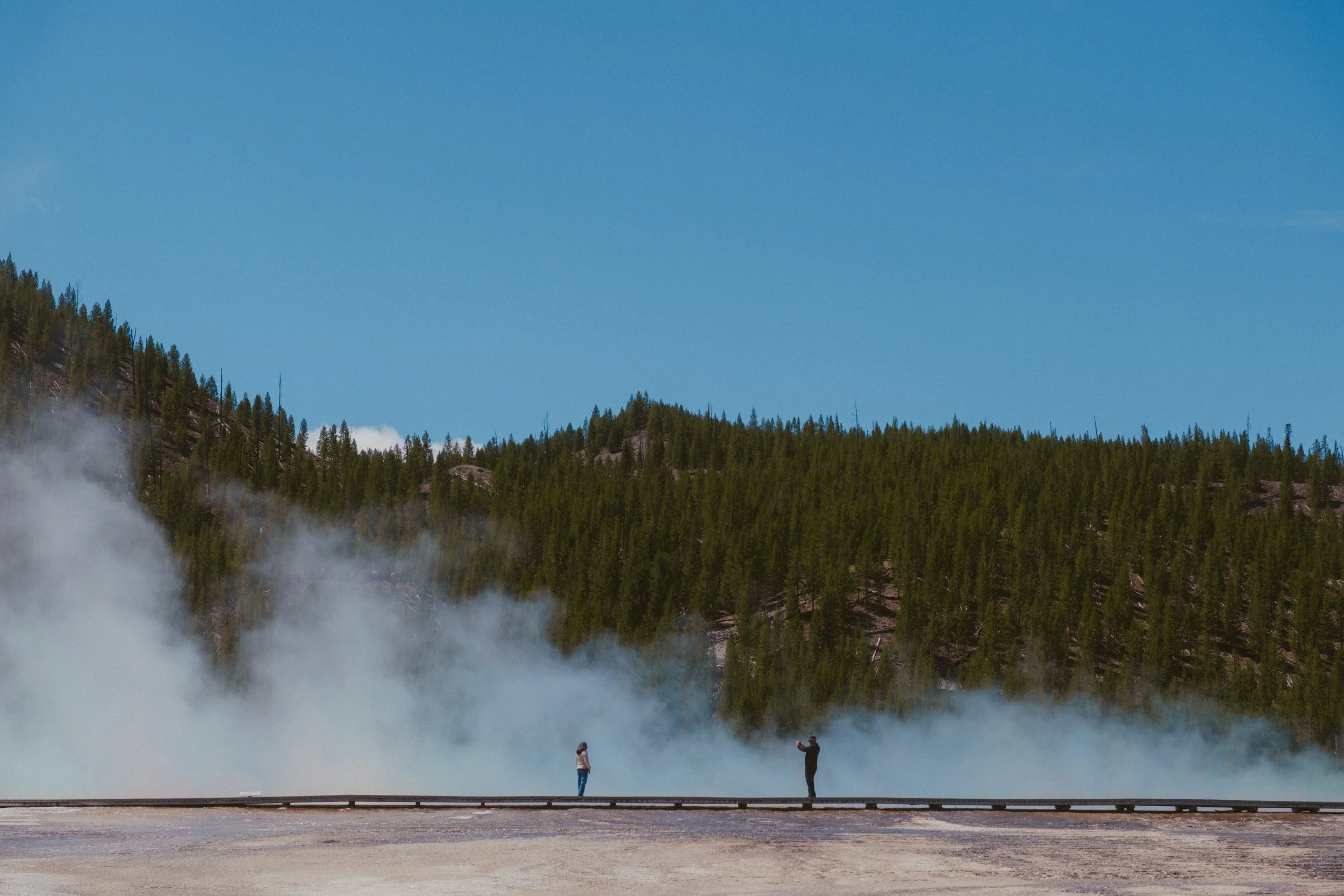 I photograph cities. Streets, trains, people. Then once in a while I end up somewhere like Yellowstone, watching steam come off the ground and bison graze fifty metres from the road, and I remember there&rsquo;s a whole other way to look at the world