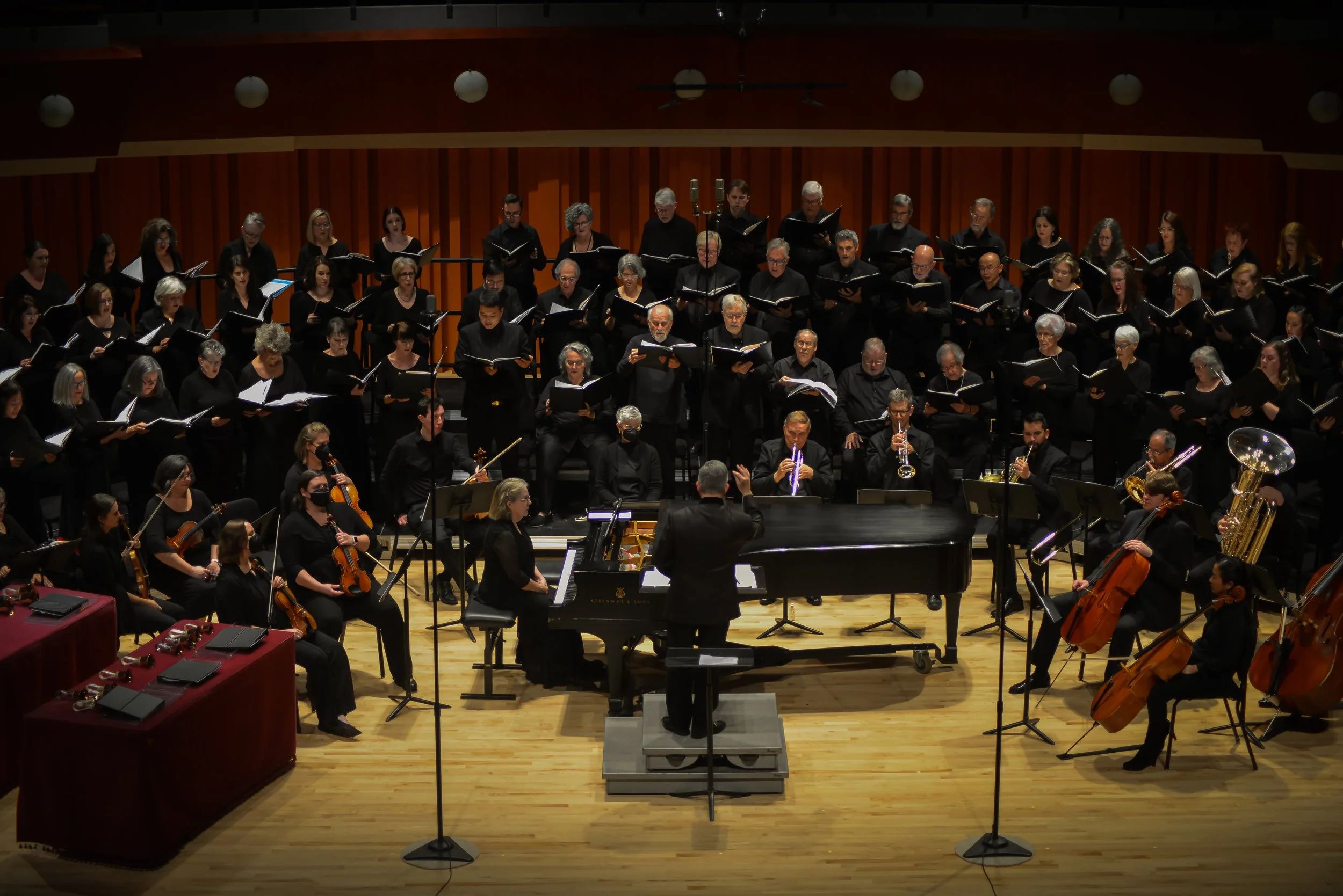 A wide shot of the chorus and orchestral accompaniment during a previous performance.
