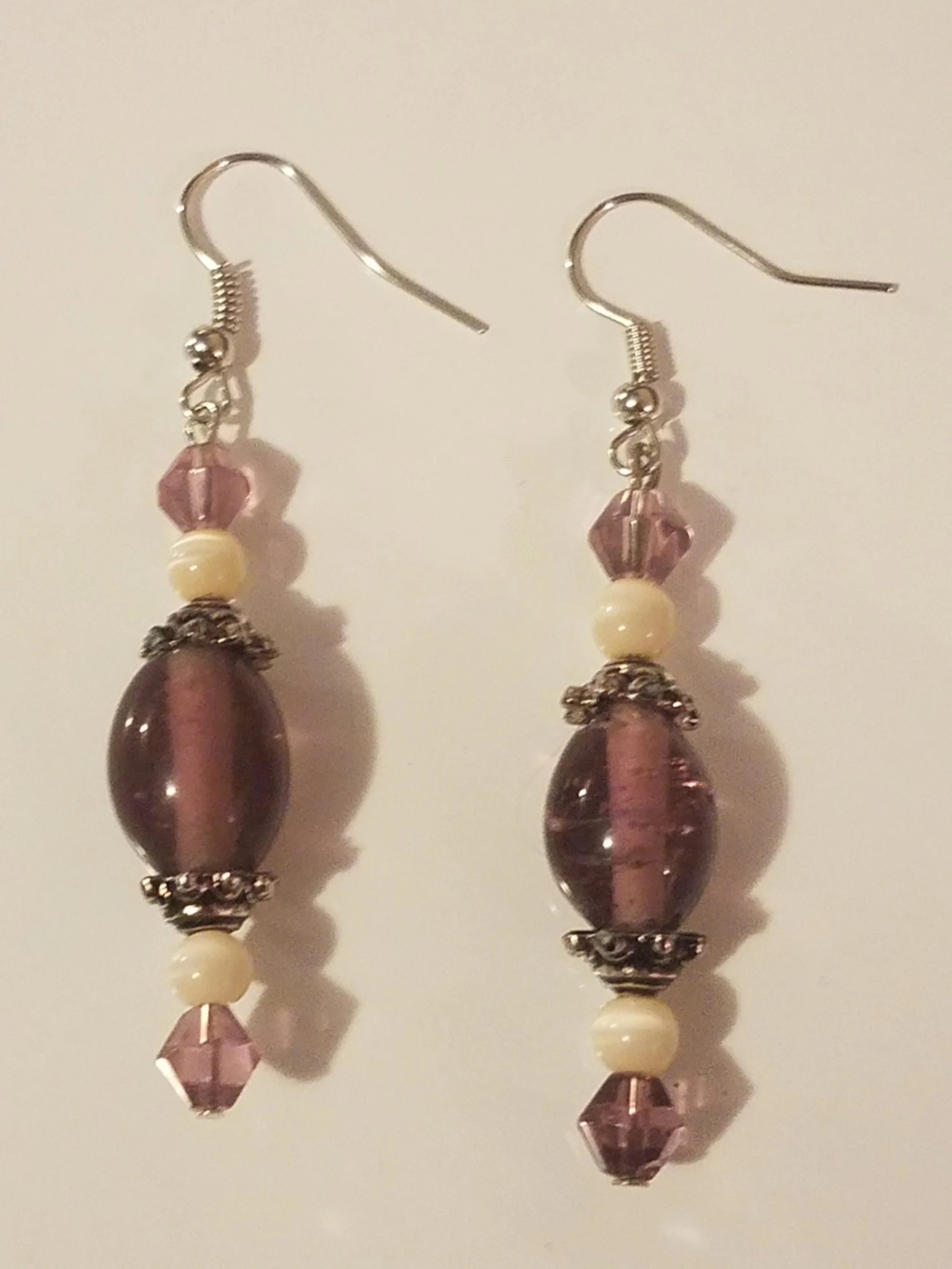Pink and cream beaded dangle earrings with metal accents.